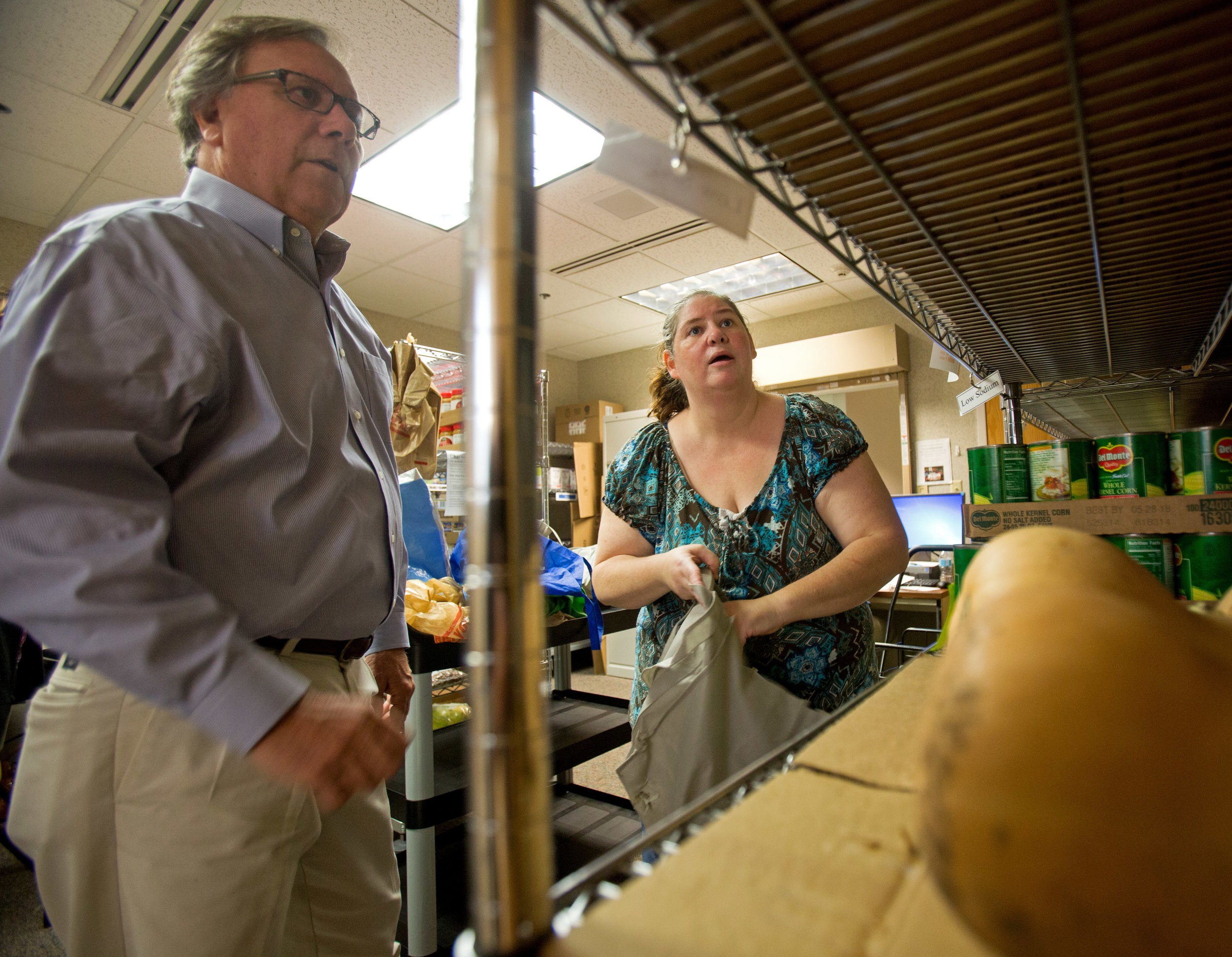 ProMedica Heart Institute cardiologist Dr. Jim Bingle helps Kim Maher of Toledo pick from different vegetable options at the food pharmacy in the ProMedia Center for Health Services on Central Ave. in Toledo on Wednesday, Oct. 19, 2016.