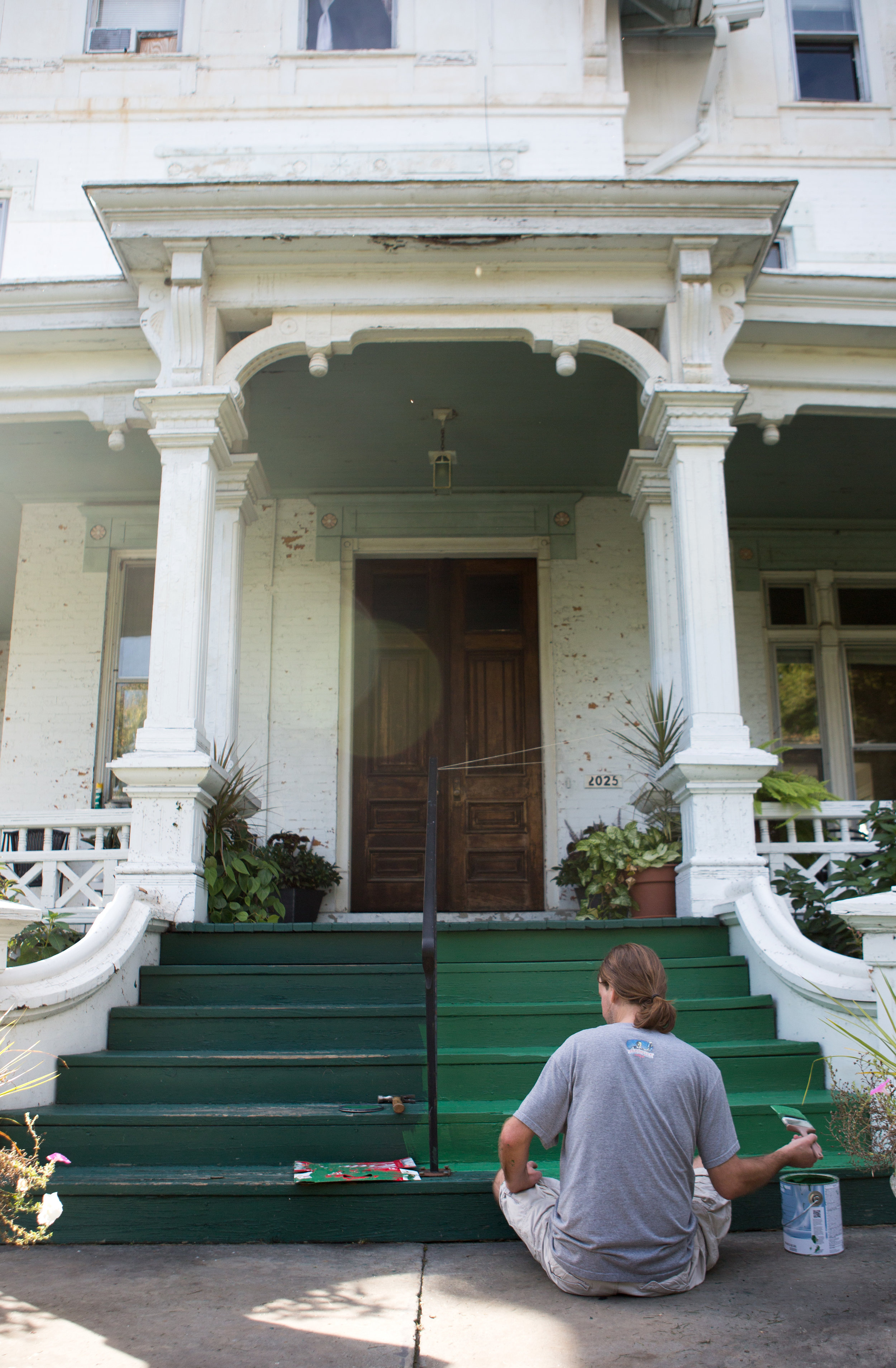 Patrick Eisel paints the front steps of the apartment building he lives in on Parkwood Ave. in the Old West End of Toledo on Wednesday, Oct. 19, 2016.