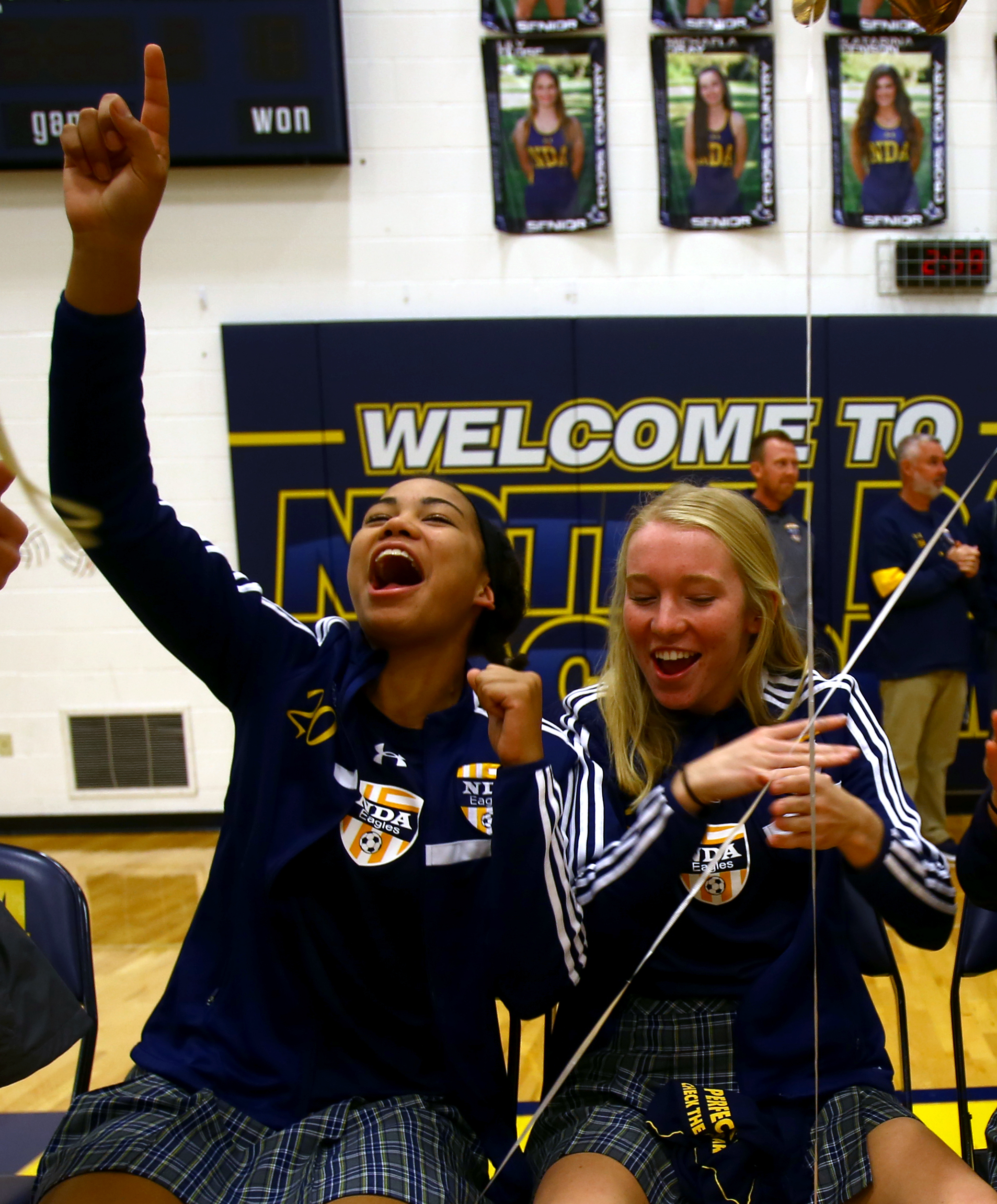 Junior defender Lexa Bauer, left, and senior forward Grace Petrie cheer during a pep rally held in Notre Dame Academy's gym in Toledo for the varsity soccer team before they head to the OSHAA state semi-final game in Sandusky on Monday, Nov. 7, 2016.