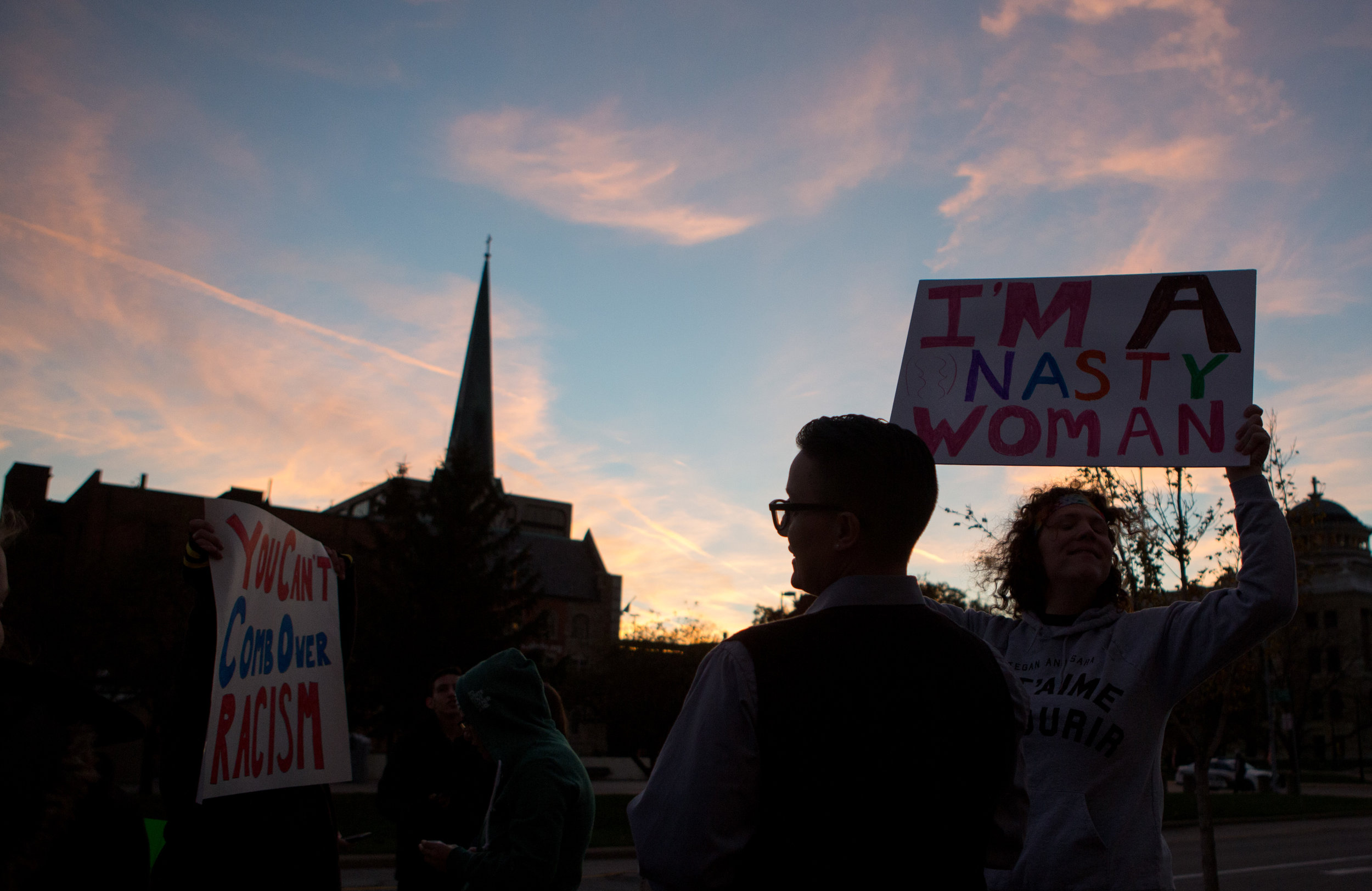  Protestors hold their signs above their heads as they gather in front of One Government Center on Jackson St. during an anti-Trump protest in downtown Toledo on Saturday, Nov. 12, 2016.