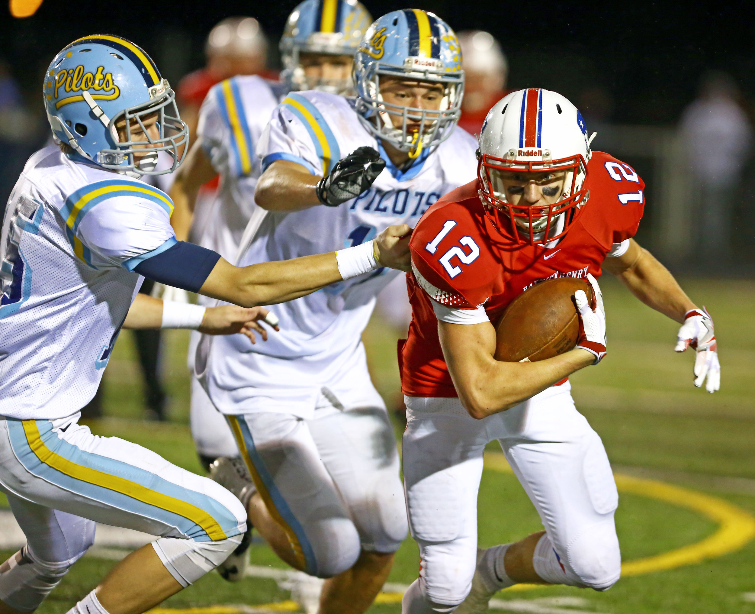 Patrick henry High School wide receiver Alex VandeBussche (12) carries the ball after a completed pass while under pressure from Ayerville High School defensive back Gavin Berner (5) and defensive end Ethan Schlachter (11) during the OSHAA Div. VI final football game at Napoleon High School in Napoleon, Oh. High School on Friday, Nov. 18, 2016. Patrick Henry won the game 21-19. 