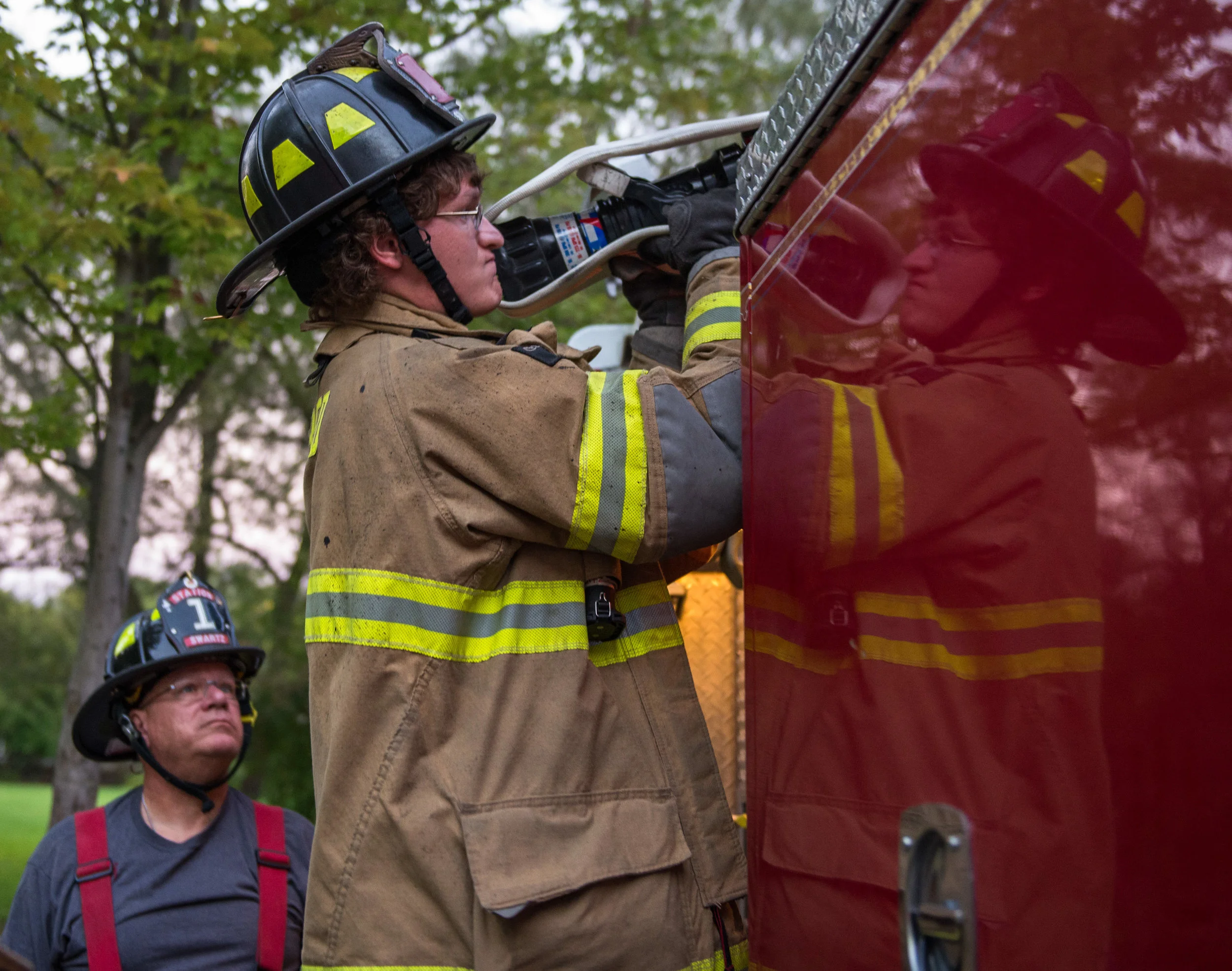 Matt Swartz of Bellefonte, Pa. starts unrolling one of the cross-lay hoses from old Engine 111 while supervised by is father and president of Bellefonte's Logan Fire Company, Mike Swartz, during the company's weekly training session at the KemClean