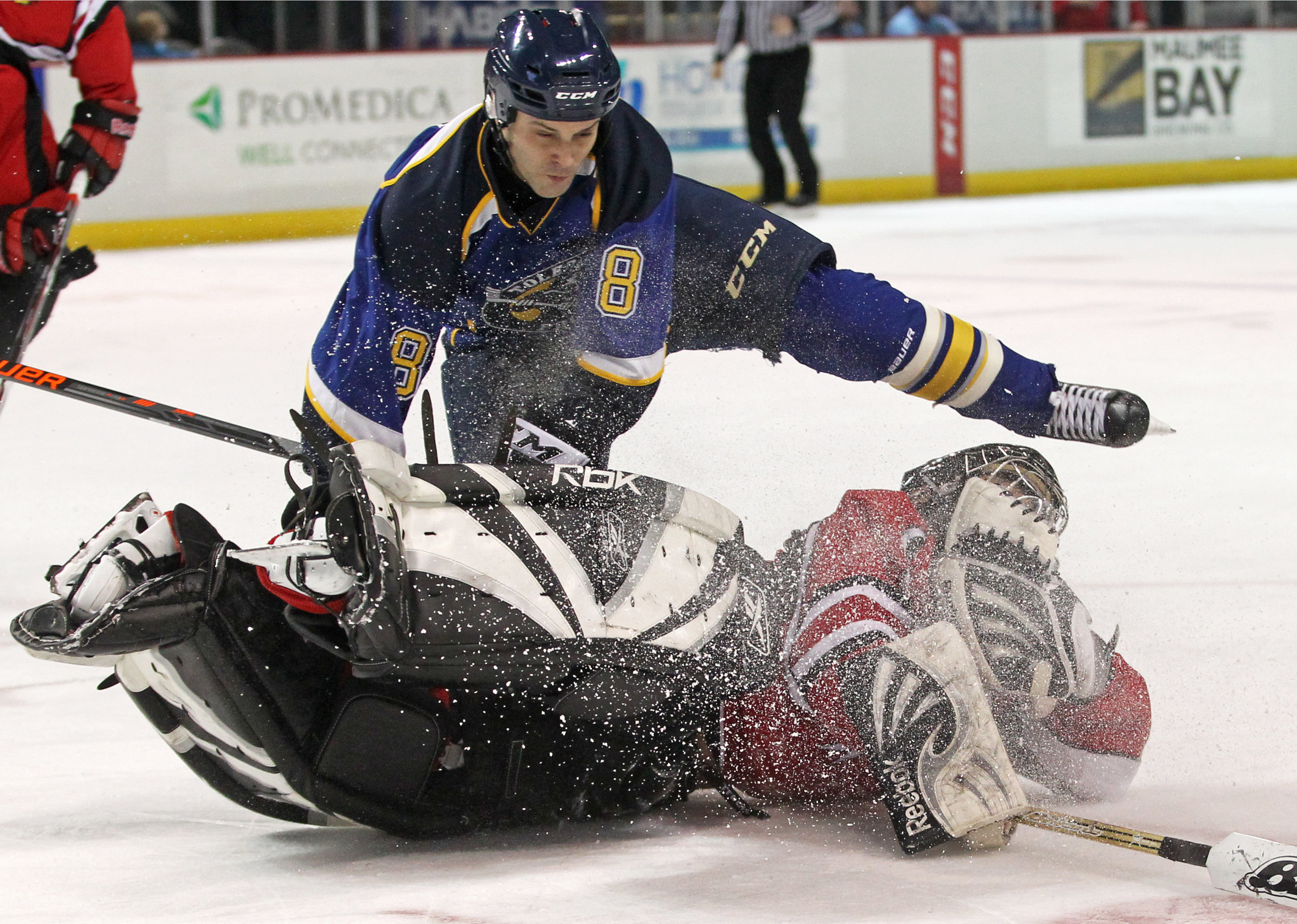 The Toledo Police's Jeff Breeze is launched over the Fire Department's goalie Brian Drouillard after diving on the puck during the annual Battle of the Badges hockey game between the Toledo Fire and Police Departments at the Huntington Center on Saturday, Dec. 3, 2016.