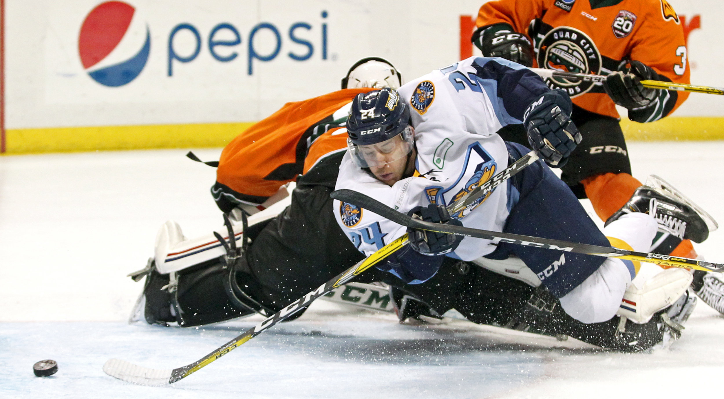 Toledo Walleye forward Tylor Spink (24) dives around Quad City Mallards goalie C.J. Motte as he slides the puck into the net, scoring the first goal of the ECHL hockey game at the Huntington Center on Saturday, Dec. 3, 2016. 