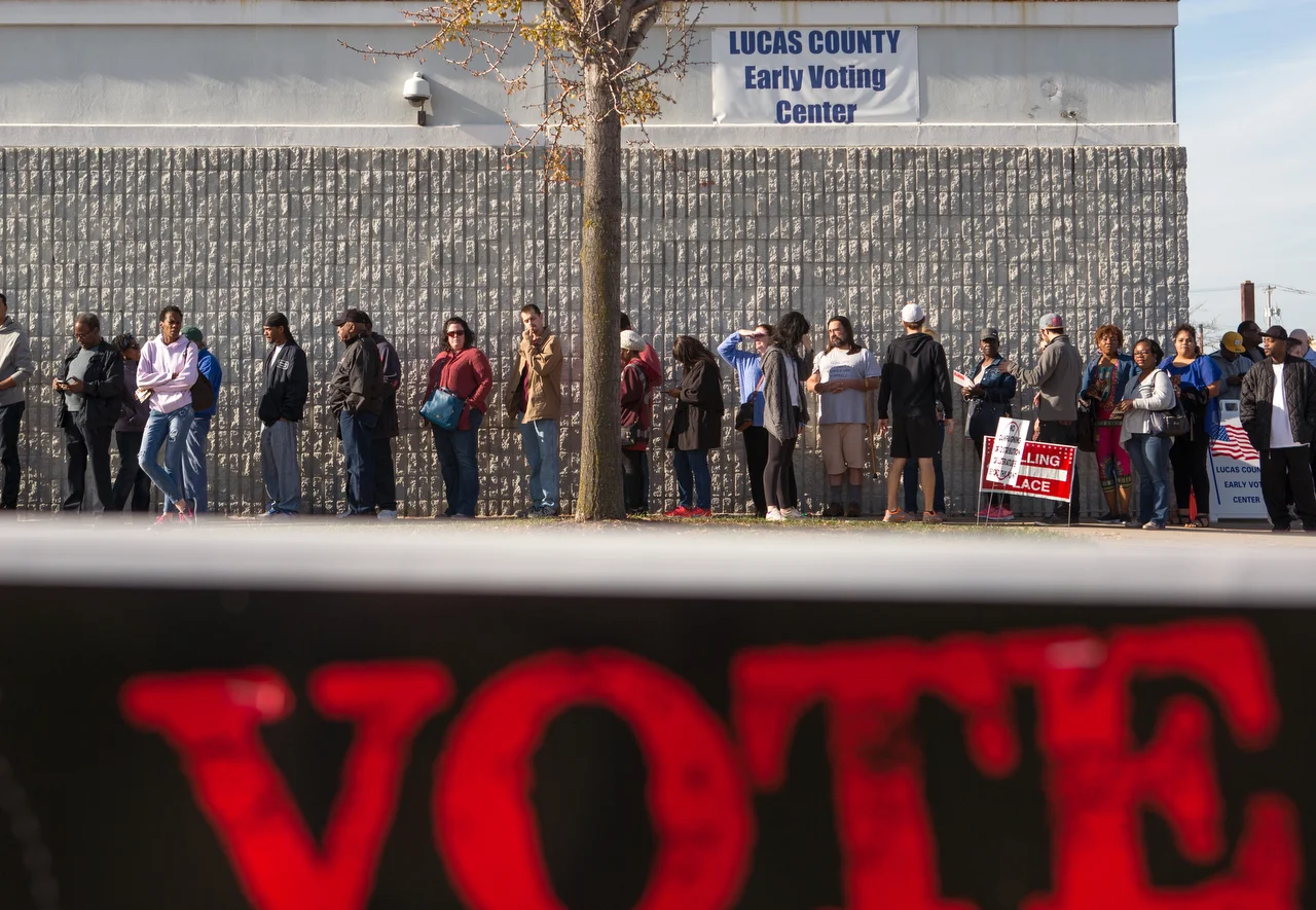  Early voters wait in a line that wraps around the outside of the Lucas County Early Voting Center on Monroe Street in Toledo, Oh. to cast their vote in the upcoming election on Saturday, Nov. 5, 2016. 