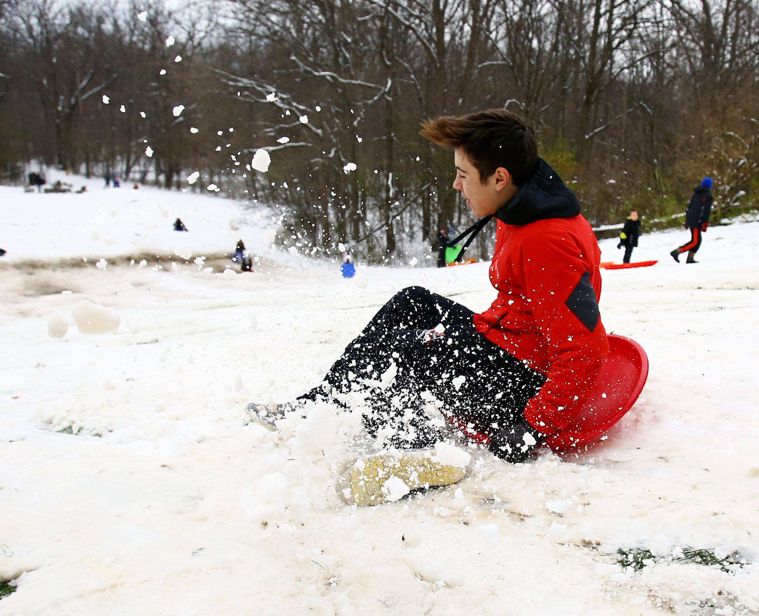Cardinal Stritch High School student Paul Latz of Toledo jumps on to his saucer sled at the sledding hill in Pearson Metropark in Oregon, Oh. during a snow day on Monday, Dec. 12, 2016. 