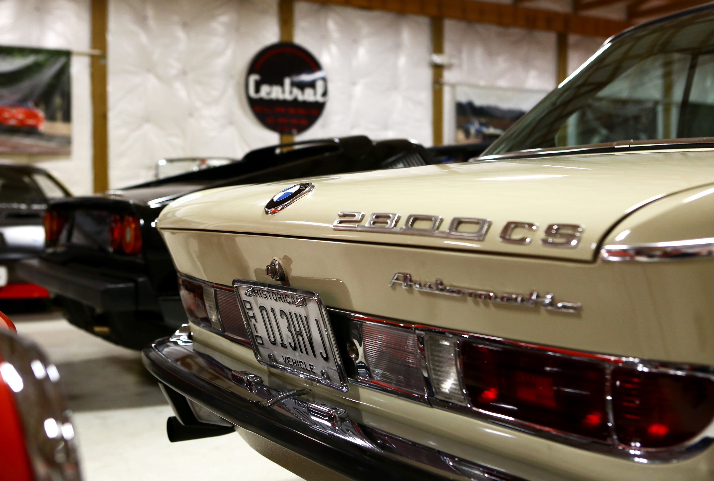 A BMW 2800cs Automatic sits next to a Ferrari 308 GTB along with the rest of Central Classic Cars' extensive inventory. 