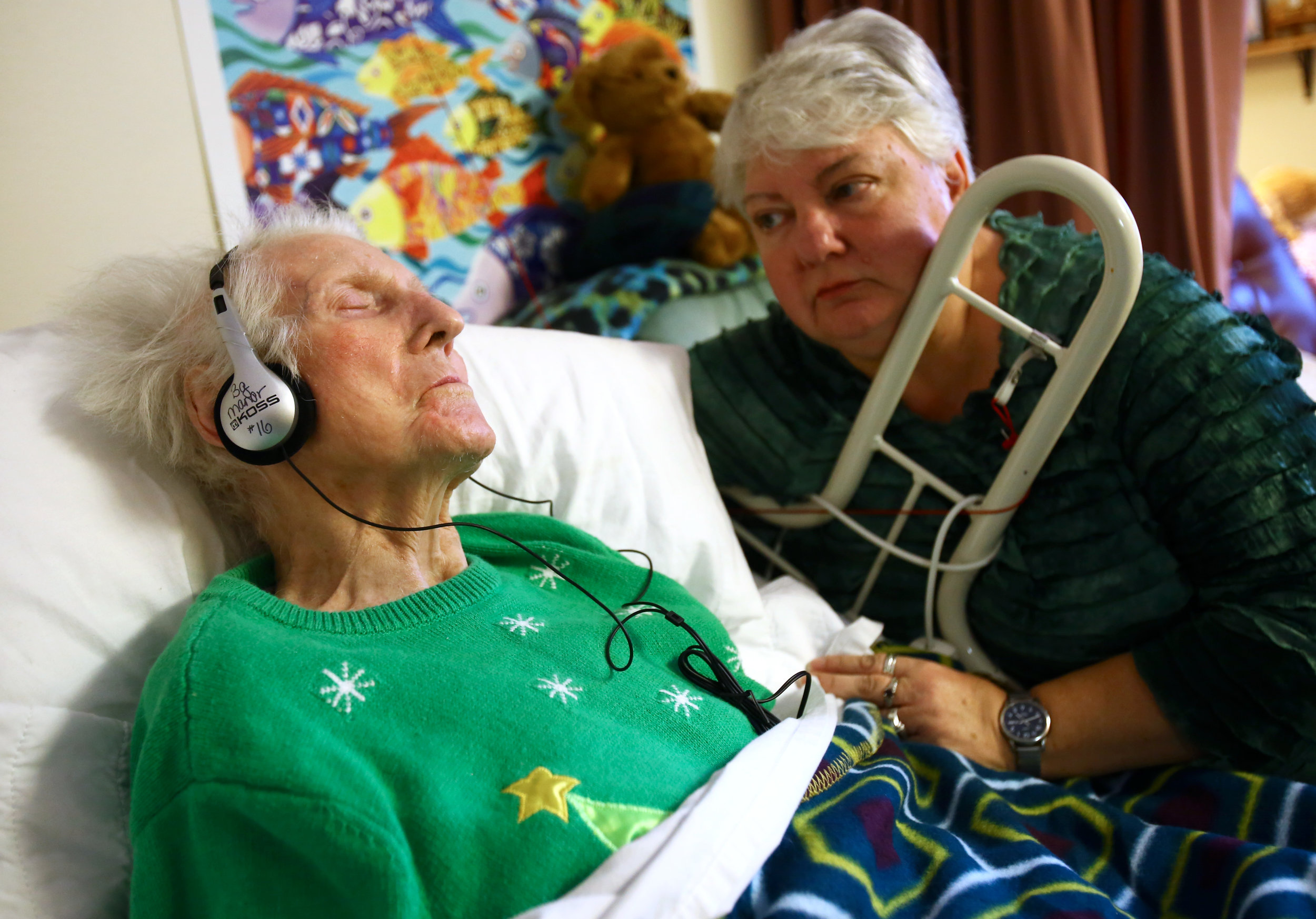 Nancy Shrider of Bowling Green, right, watches over her mother Donnagene Shrider as she listens to a mix of Christmas music on an iPod Shuffle as part of the Music and Memory program at Bowling Green Manor nursing home in Bowling Green, Oh. on Monday, Dec. 19, 2016.