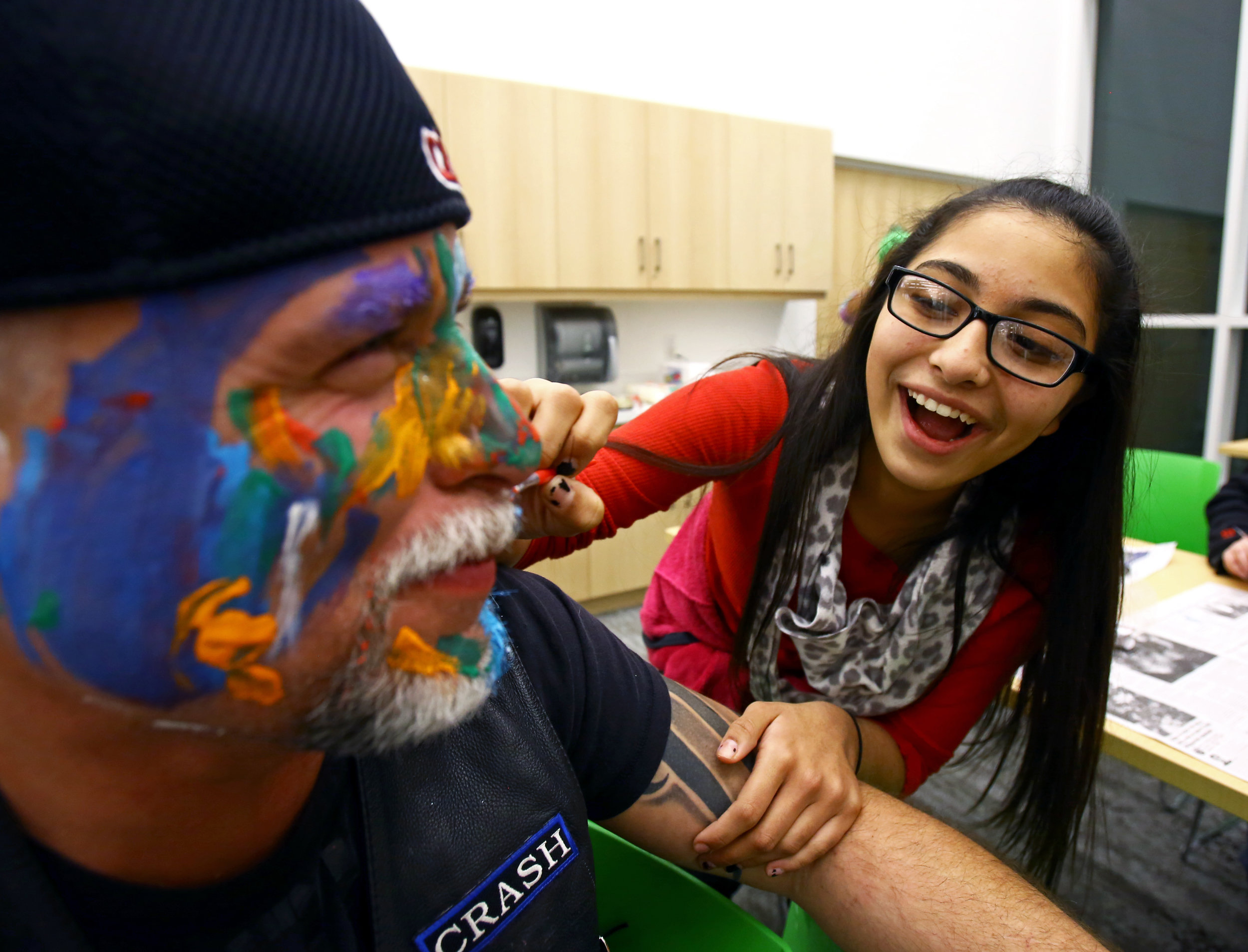 "Little Shorty" of Toledo paints on Warriors for the Children member "Crash's" face during the arts and crafts portion of the monthly Bullfrogs Against Bullying peer support group at the King Road Branch Library in Sylvania, Oh. on Monday, Dec. 19, 2016. 