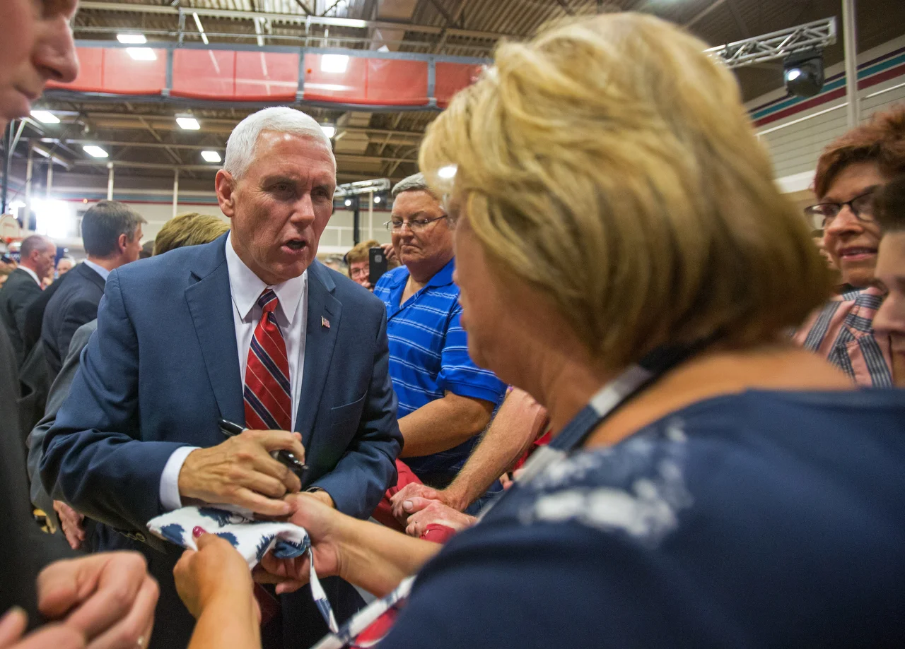  Republican vice presidential candidate Mike Pence signs a supporter's purse after his appearance at the the Rossford Recreation Center on Friday, Oct. 7, 2016.&nbsp; 