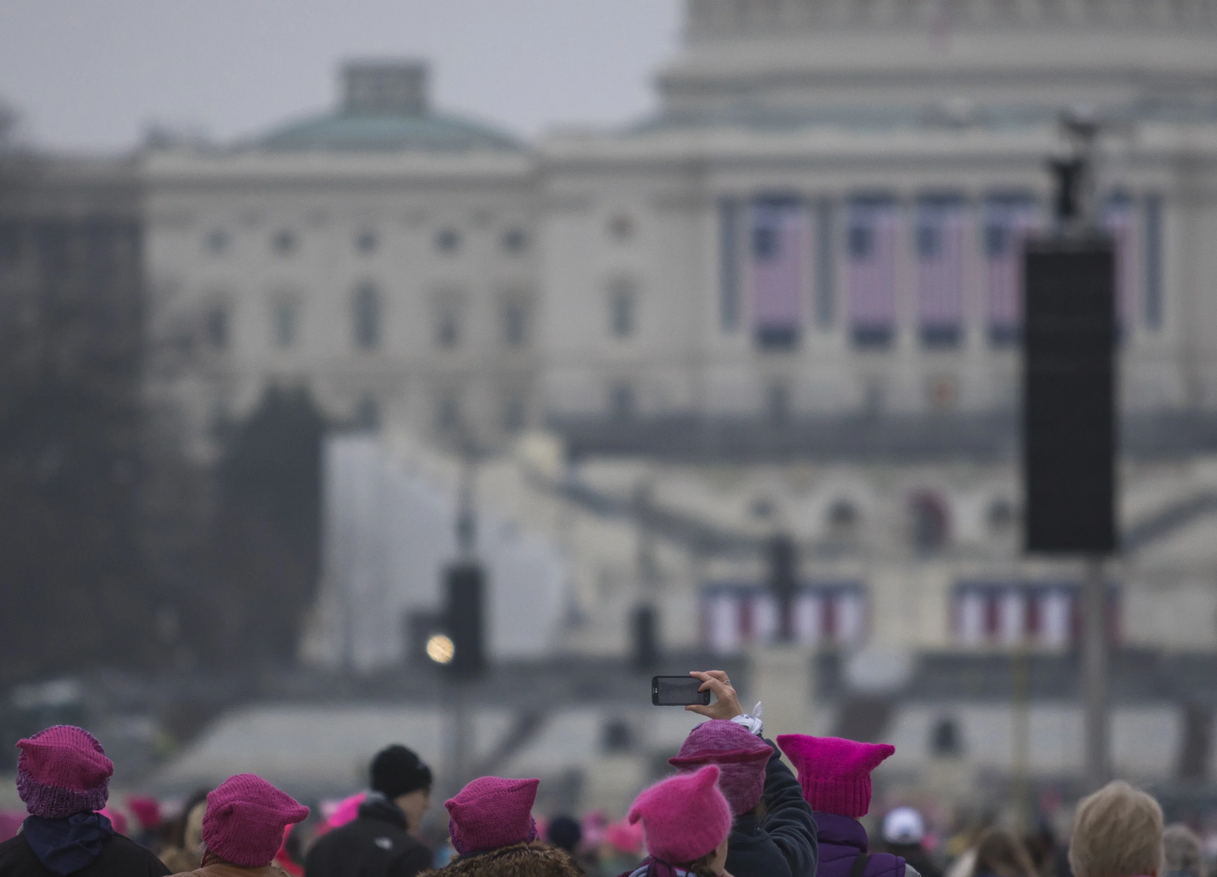 A Women's March on Washington participant snaps a photo of the Capitol Building as crowds mass onto the National Mall early on Saturday, Jan. 21, 2016.