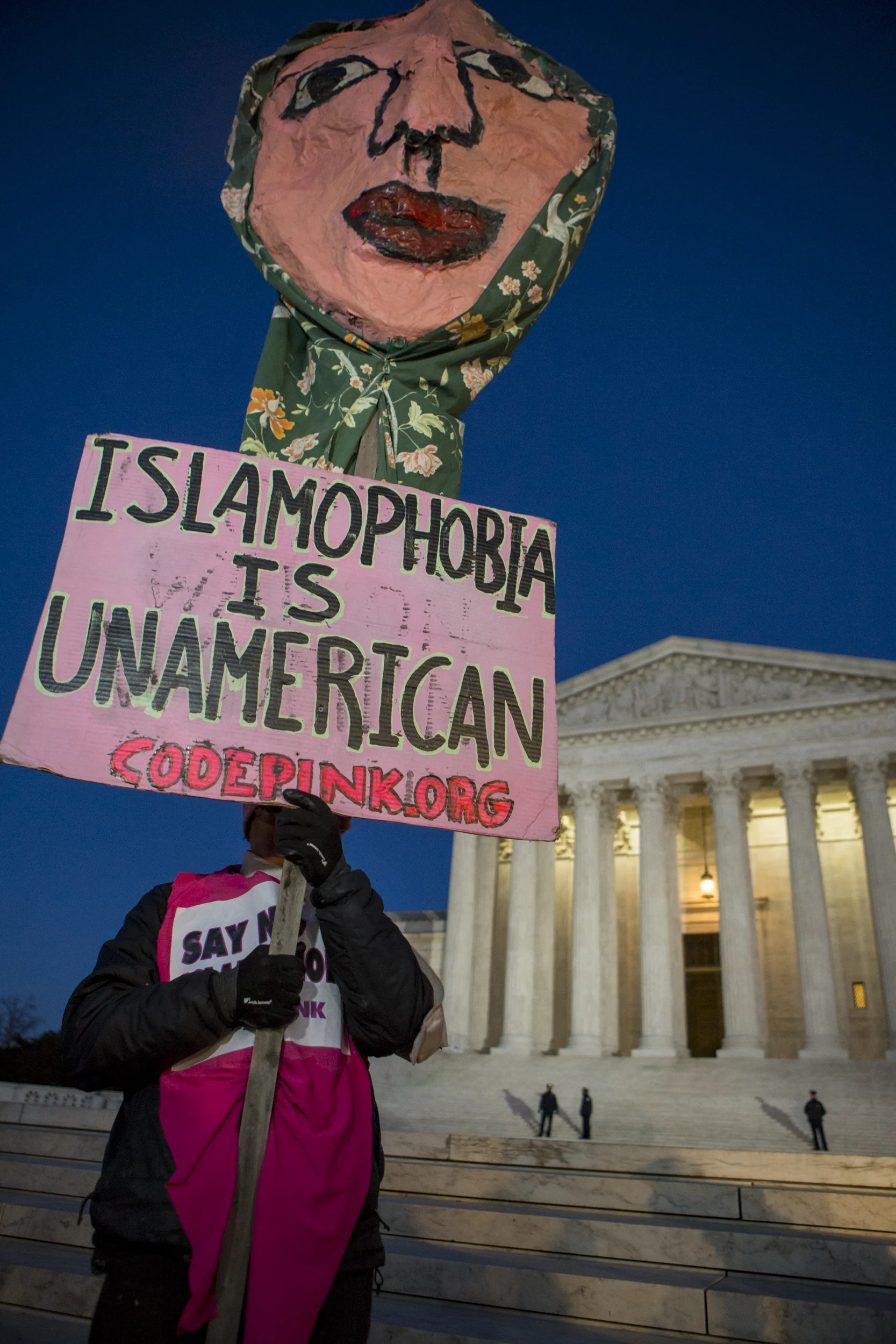 A protestor holds a sign on the steps of the Supreme Court during the rally organized by democratic lawmakers against President Trump's recent executive orders.