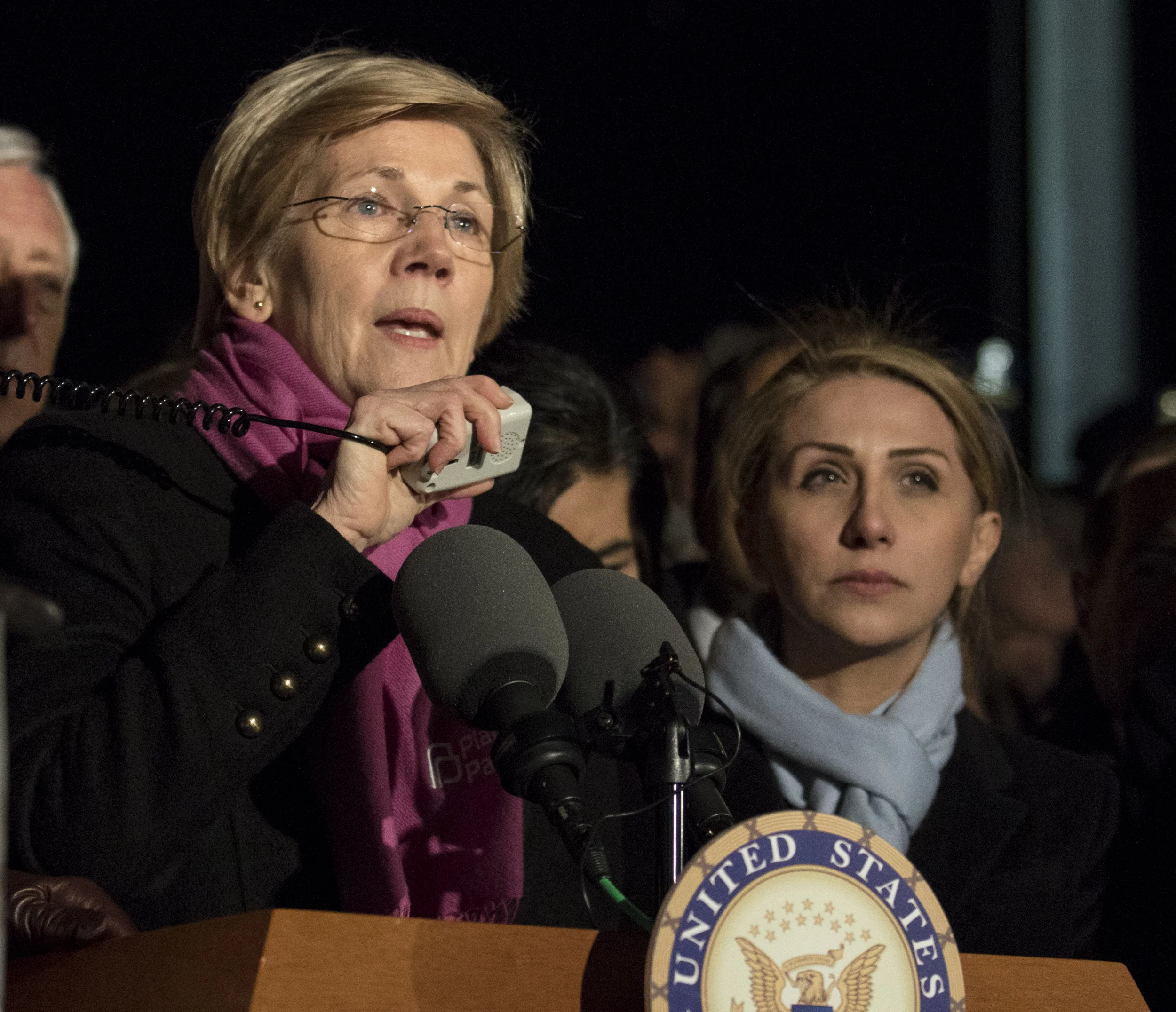 Senator Elizabeth Warren (D-Ma.) speaks out against President Trump's recent executive orders with Farah Amer Kamal, right, of Iraq who is now barred from returning to her home country to visit her husband and father.
