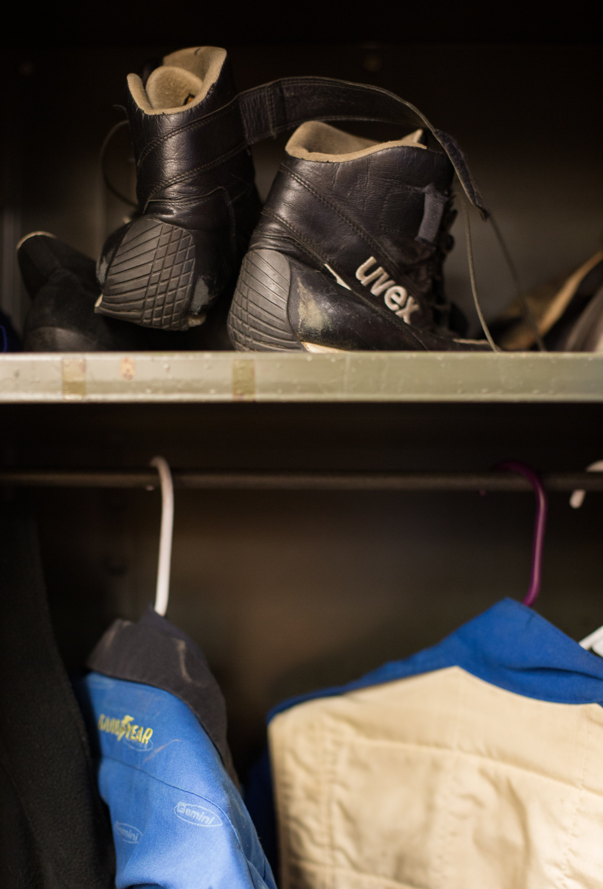  The team's racing shoes and jumpsuits hang in a cabinet in the the lab. 