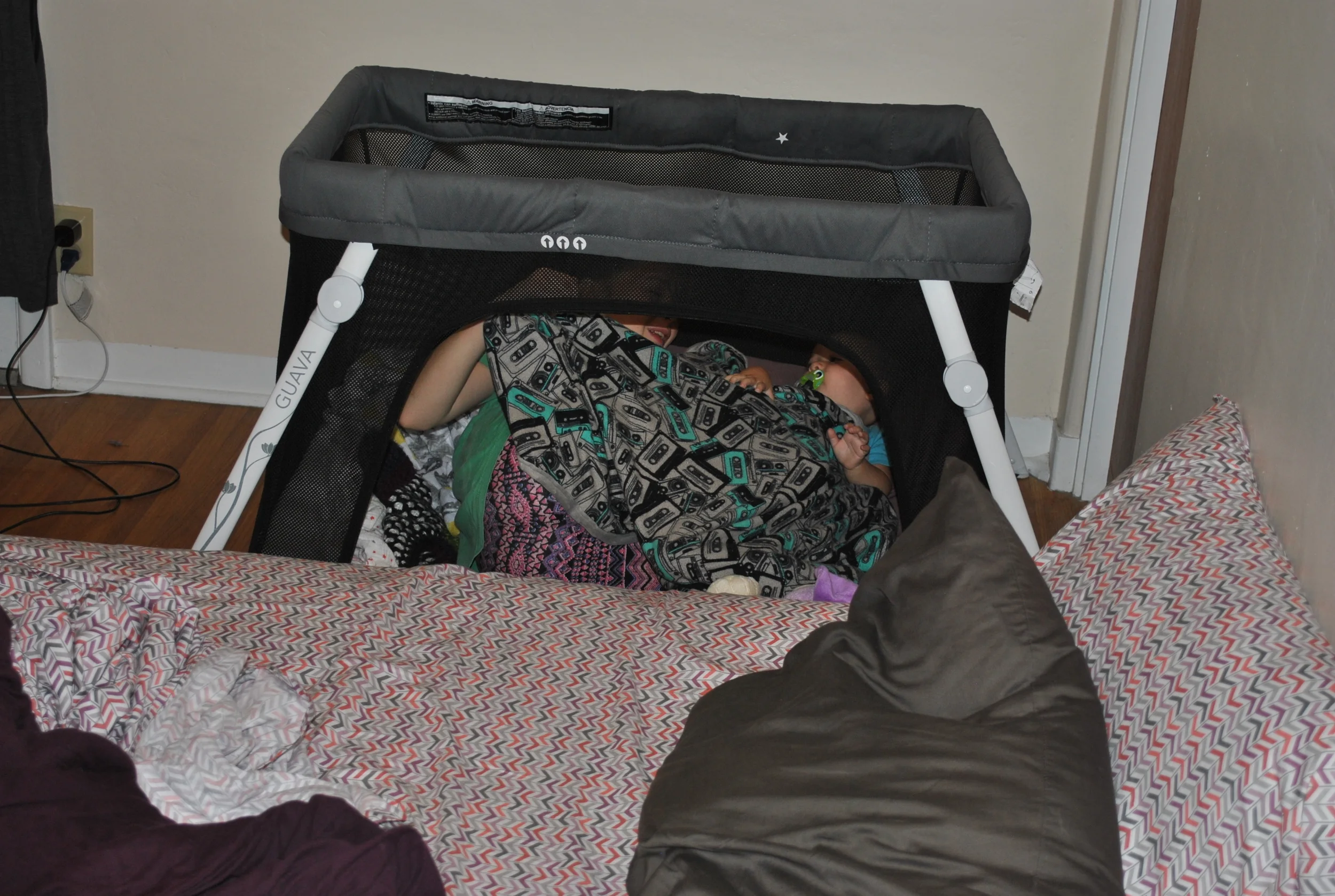 Our kid with her aunt in the little baby cage. Is it still a cage if it has an open exit? 
