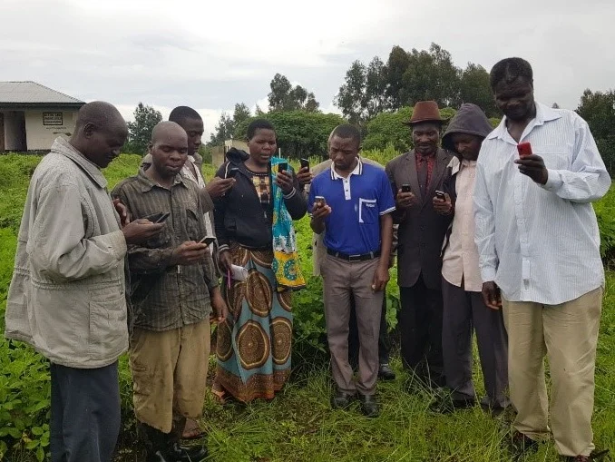 Farmers in Tanzania using mobile phones to receive information about improving agricultural productivity. Taken in January 2018 during Tanzania field mission by Landell Mills’ Evaluation team