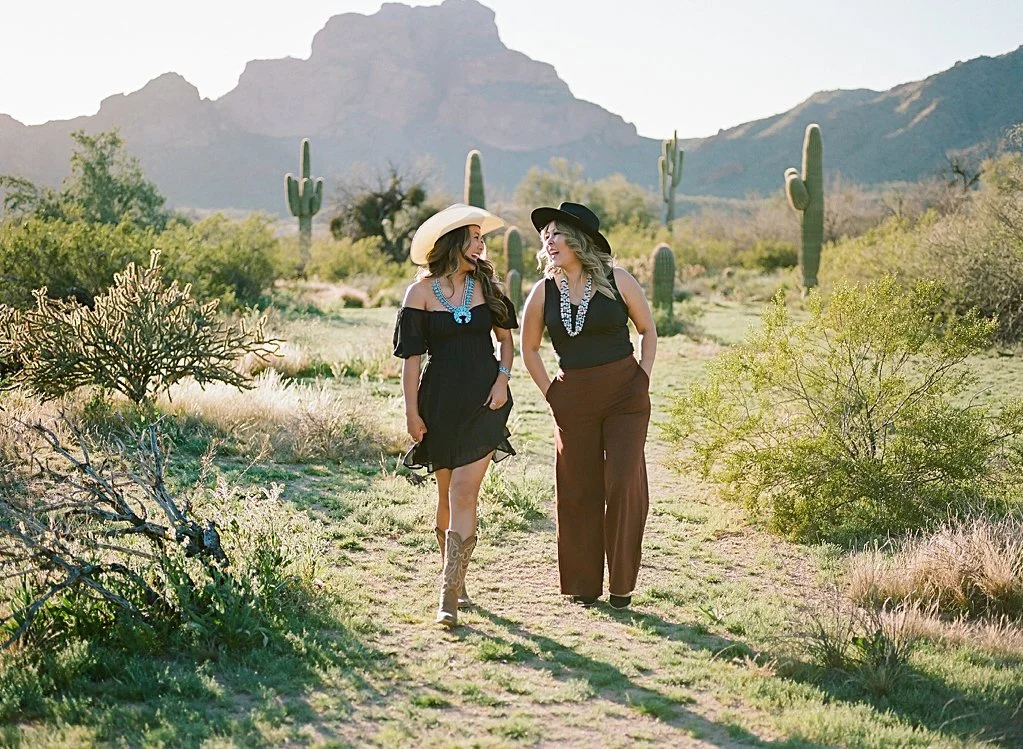 Navajo mother and daugther walking in the desert smiling at each other. Photo is taken near Phon D. Sutton Recreation area.