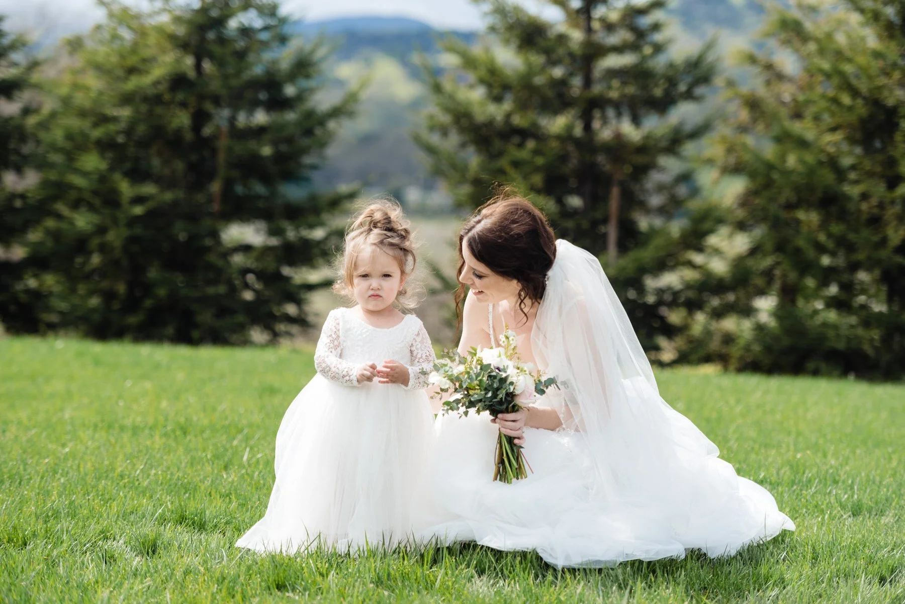 a small child frowns in a wedding party photo with the bride