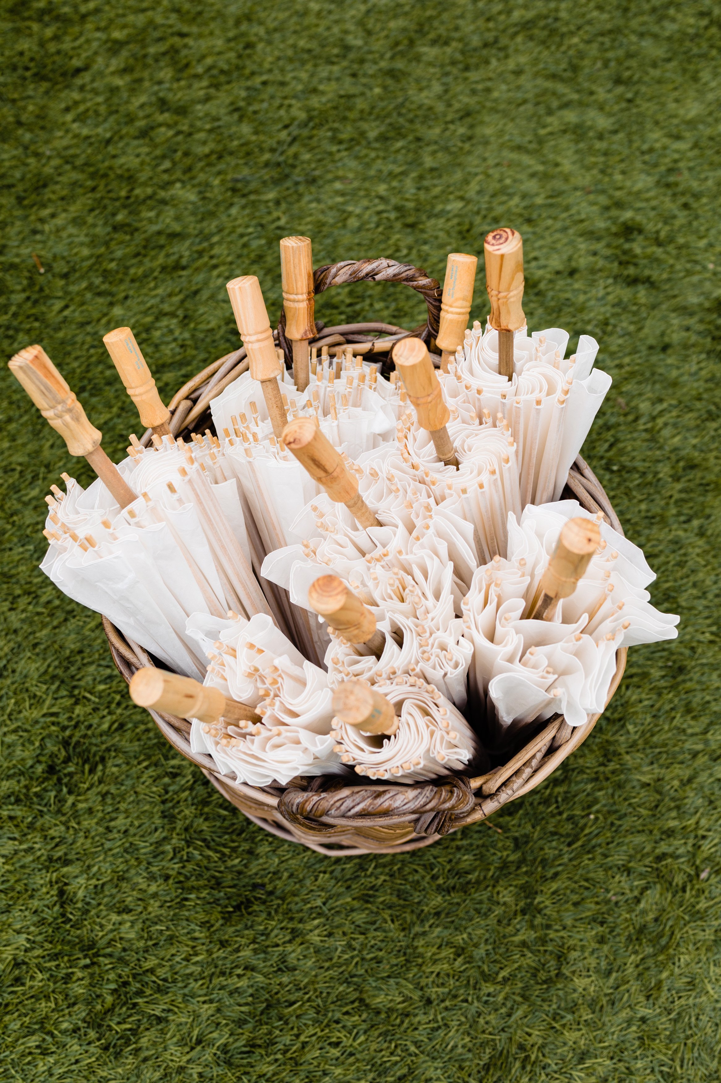 basket of sun parasols at a wedding