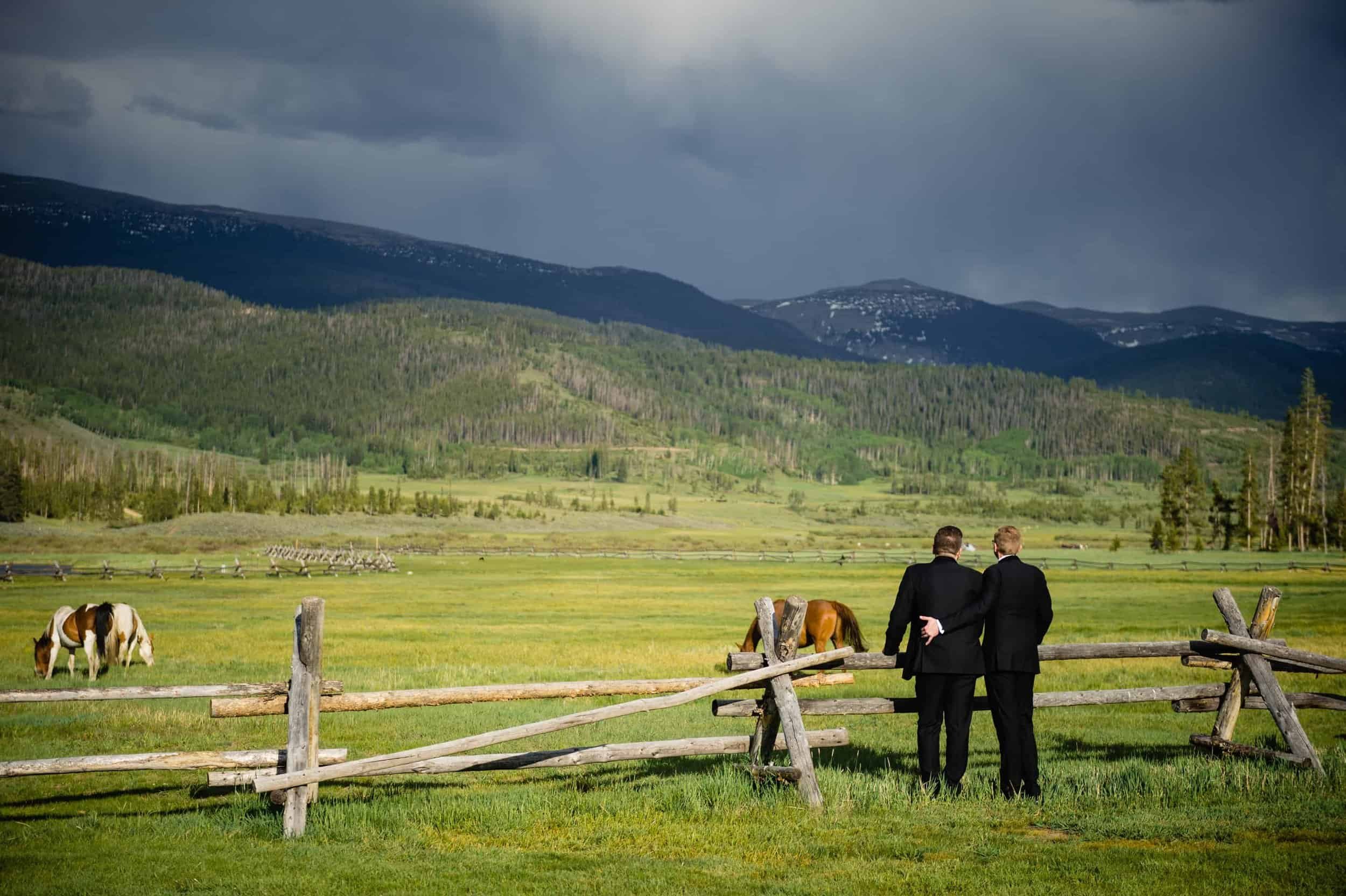 a couple holds each other in front of the mountaisn on their wedding day