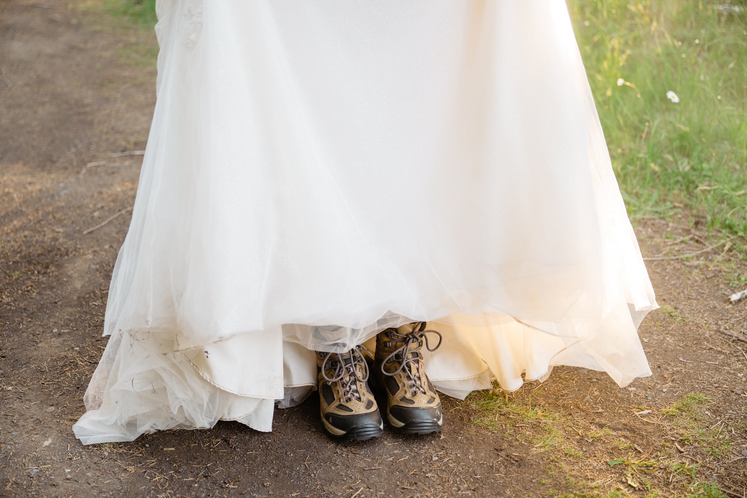 Hiking boots peeking out from underneath a wedding dress