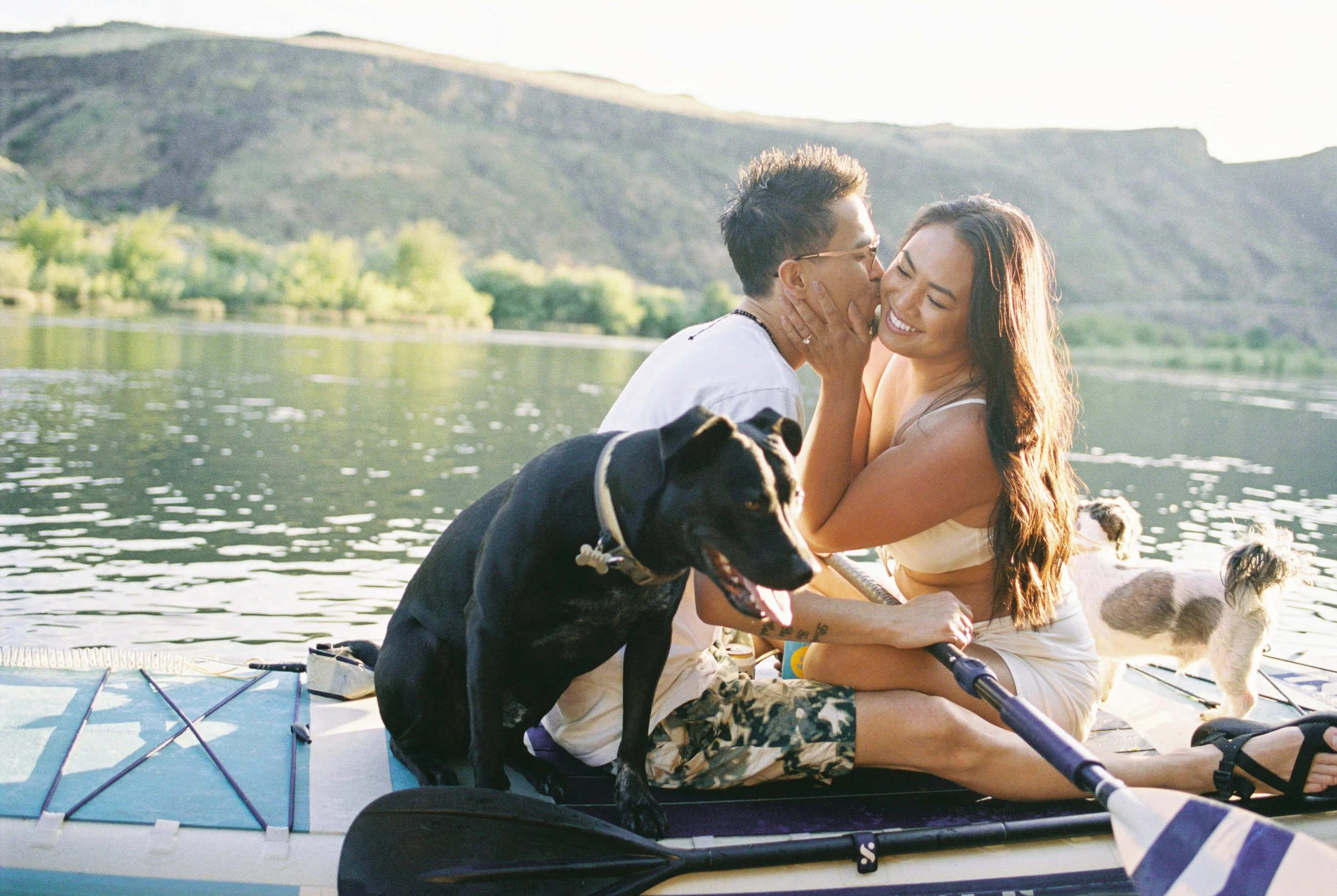 a couple kisses on a paddleboard