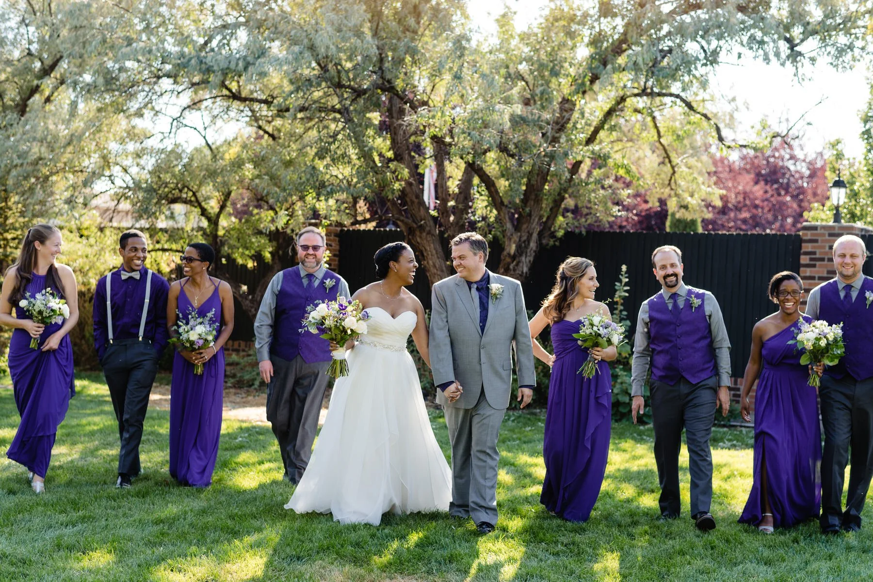 a wedding party walks across a grassy field at Lionsgate Event Center