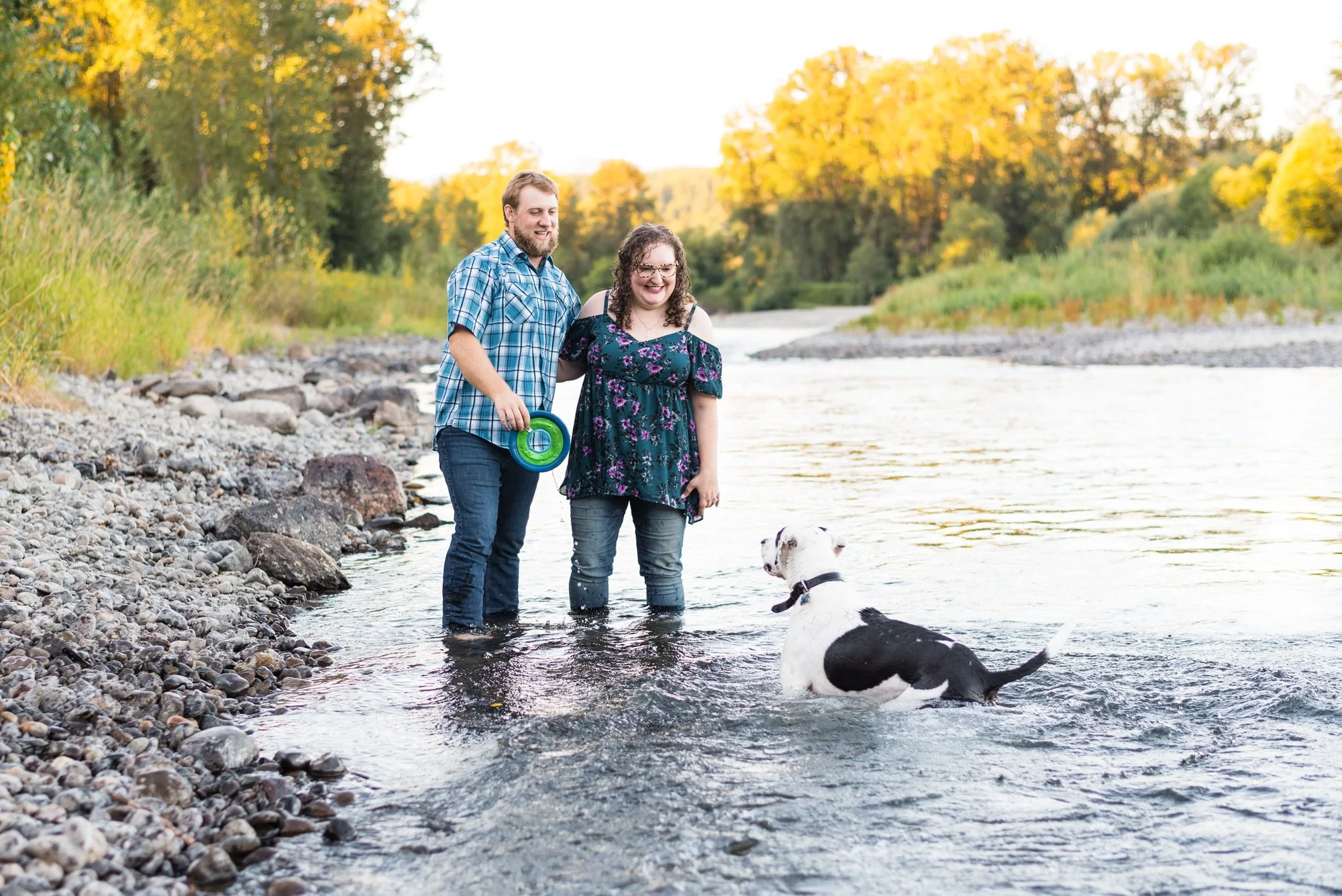 man and woman play with their dog during their Colorado engagement session