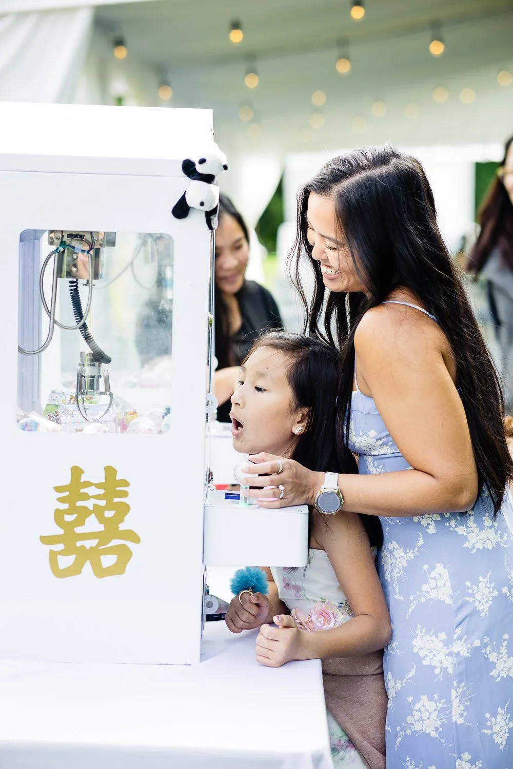guests hunt for a toy in a mini claw machine at a wedding