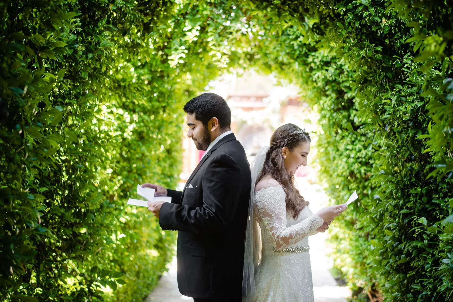 a couple stands back to back having a first look at their wedding day