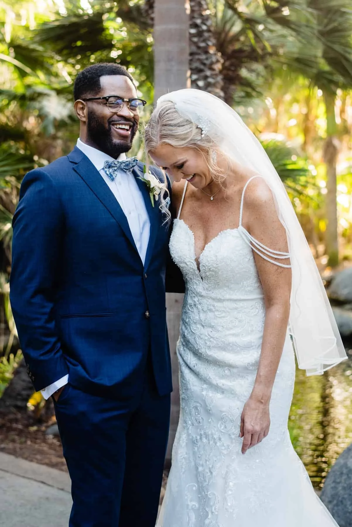 a bride and a groom laugh during their wedding portraits in Colorado
