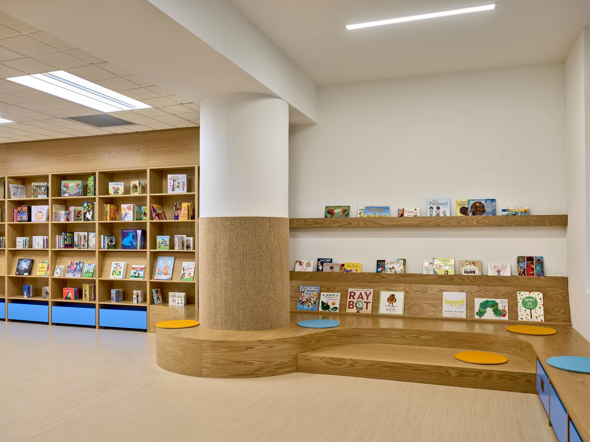 Bright beginnings with books! At La Escuela Comunitaria del Bronx, we designed the library shelves in the multipurpose room for solo exploration or group story time. Our child-height shelves, forward-facing displays, and accessible book drawers encou