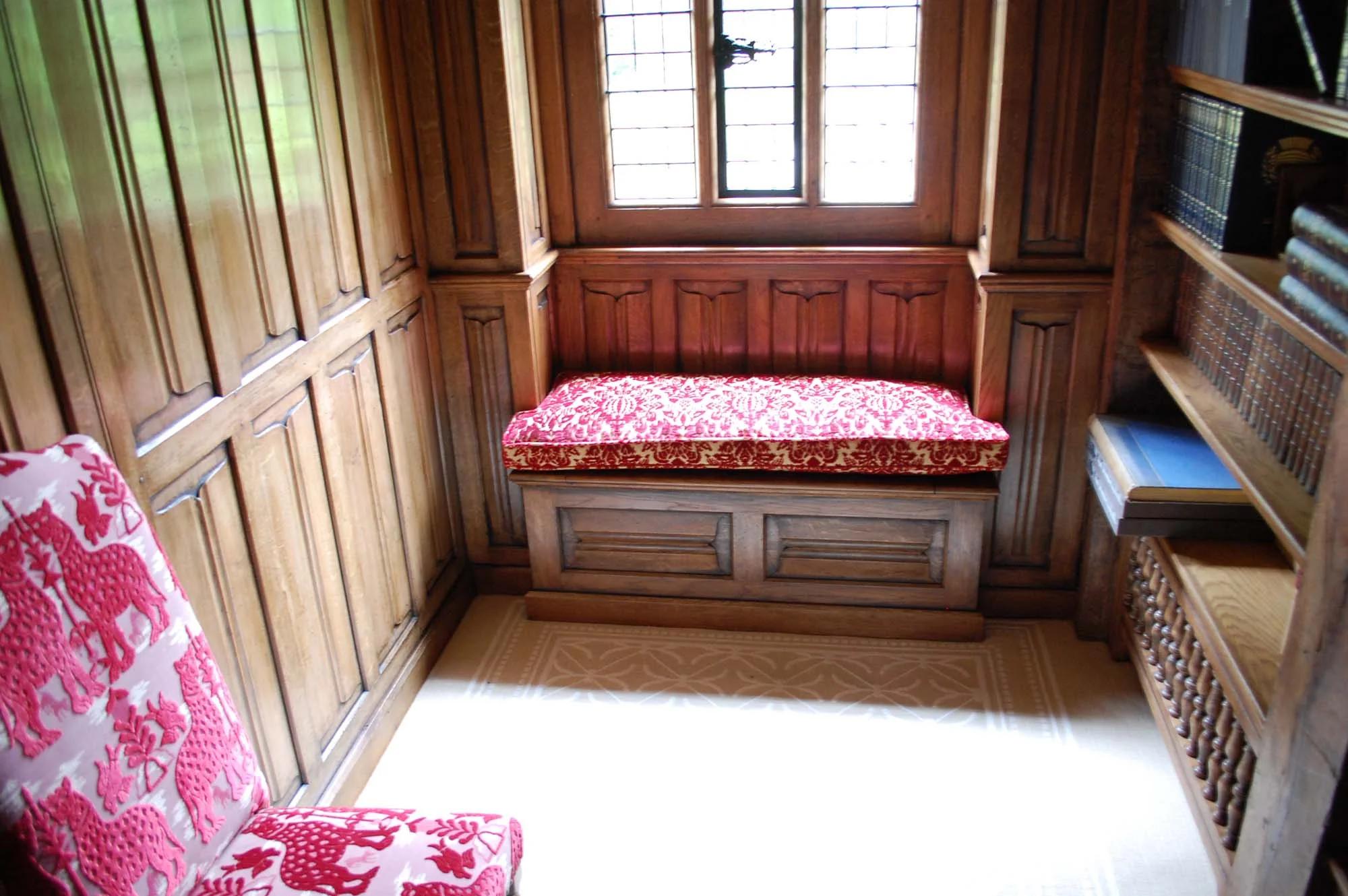 Gothic style oak panelled room with a window seat 