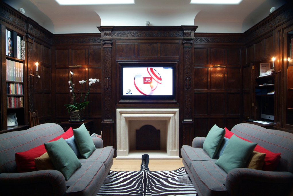 Oak panelled fire surround with hidden Tv reveal panel, in a 17th century country house style