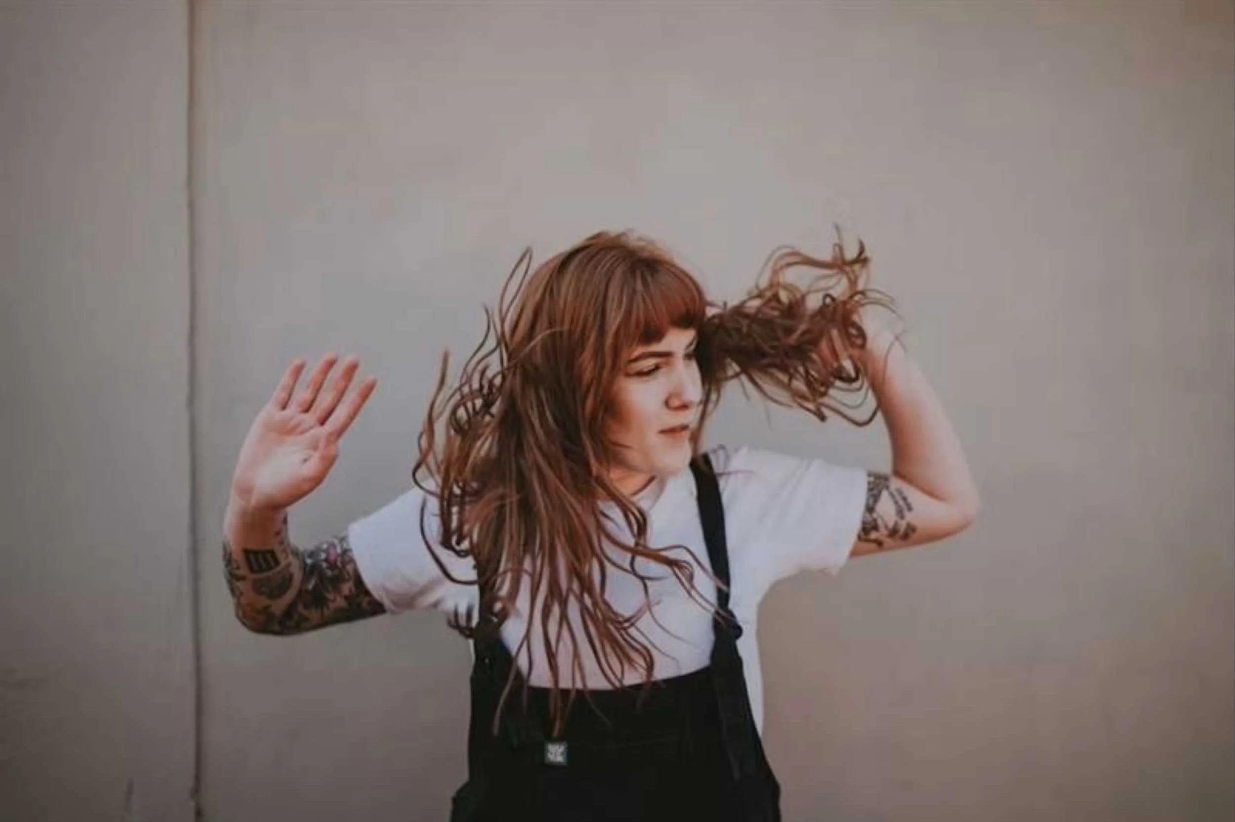 Tattooed woman with hair blowing in wind