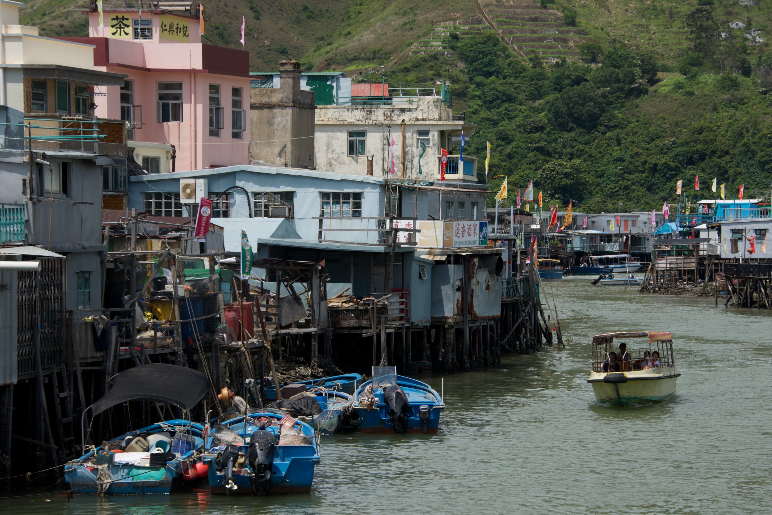 Pleasure boat passing moorings of stilted houses