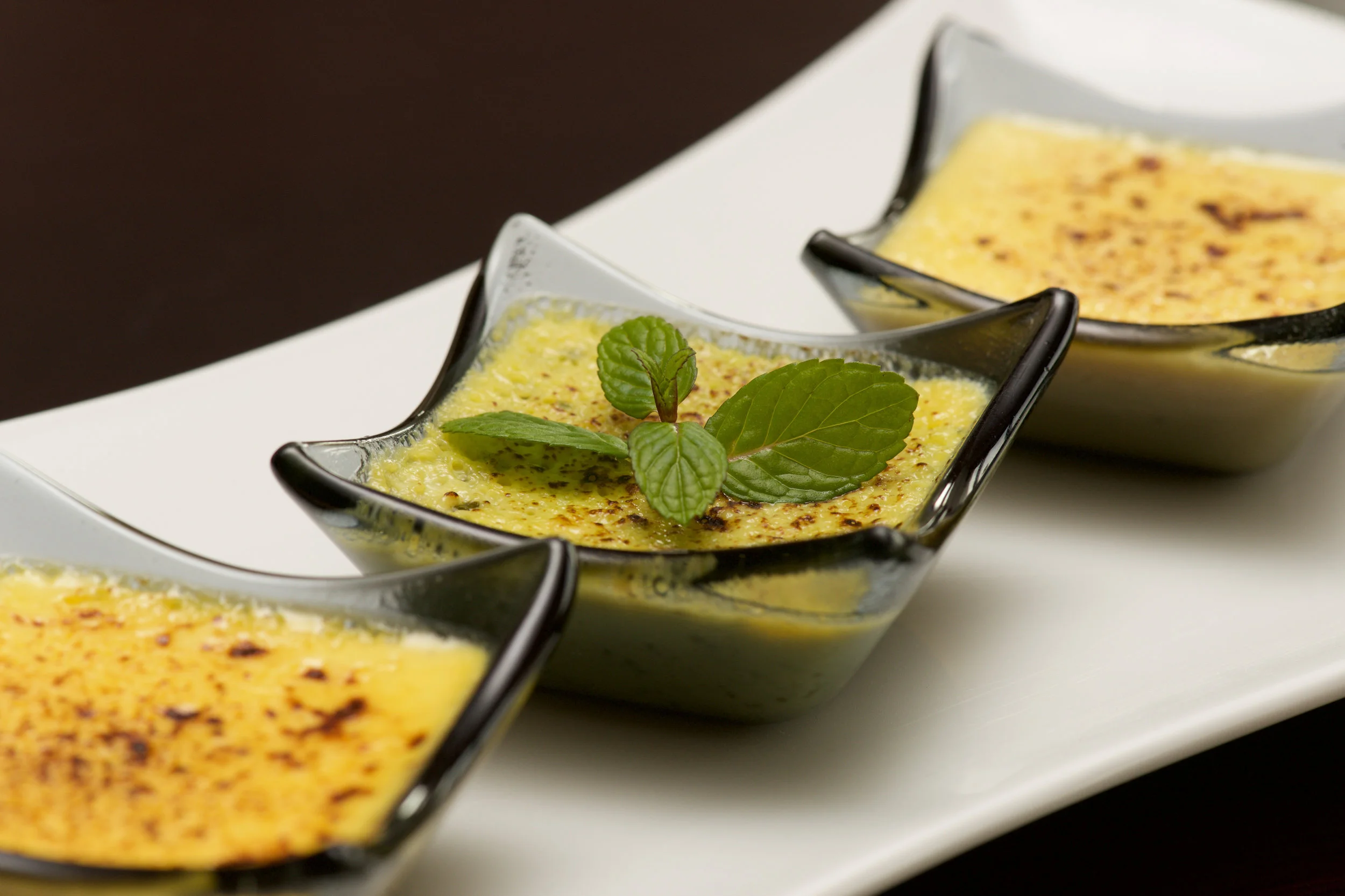 Close-up of plate of three creme brulees