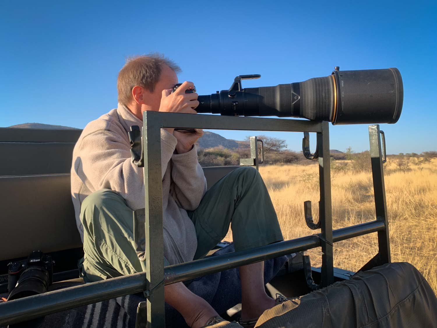 Man sits in safari truck with camera.jpg