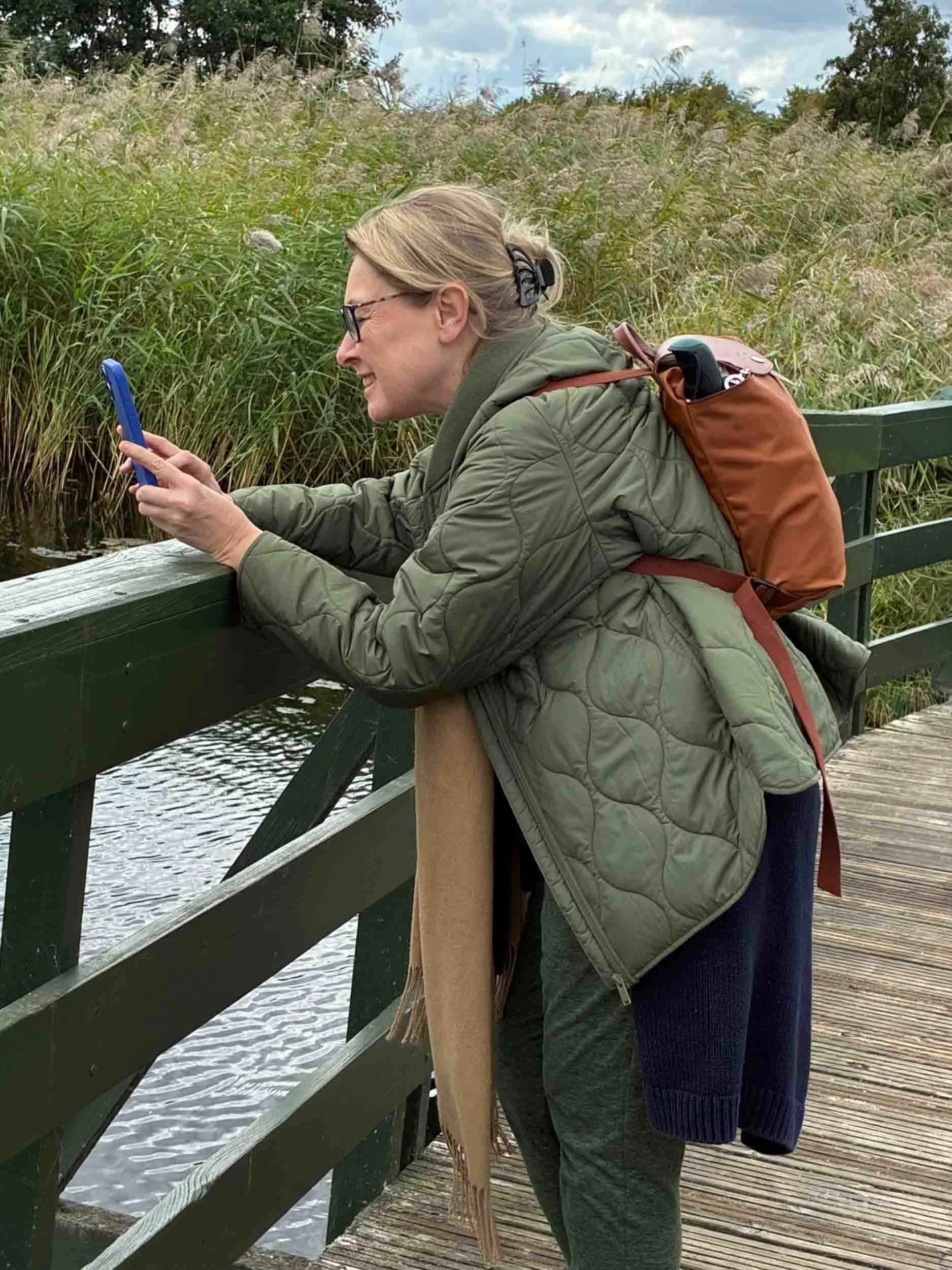 Woman stands on bridge with smartphone.jpg