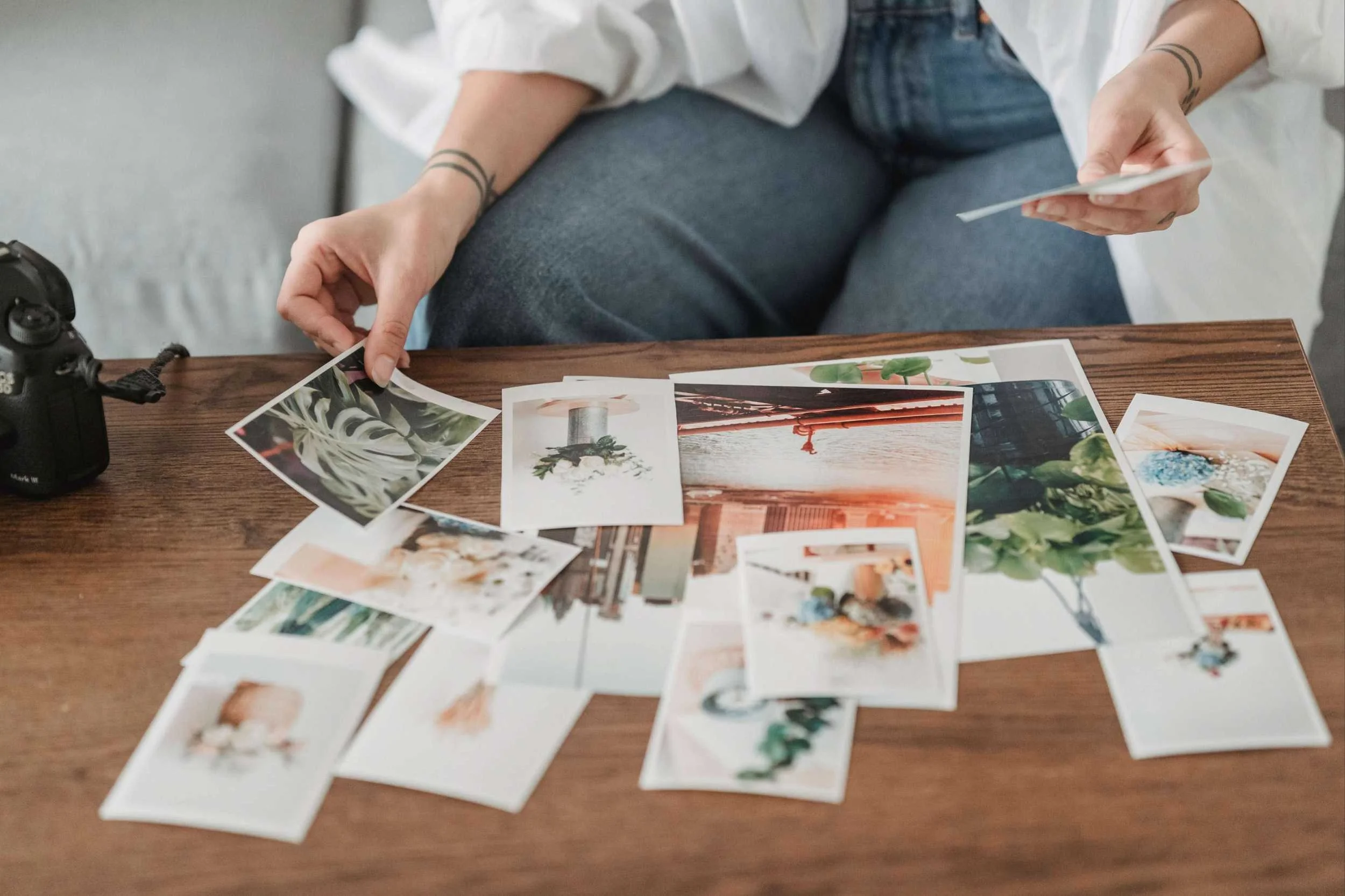 Man sits laying out prints on table
