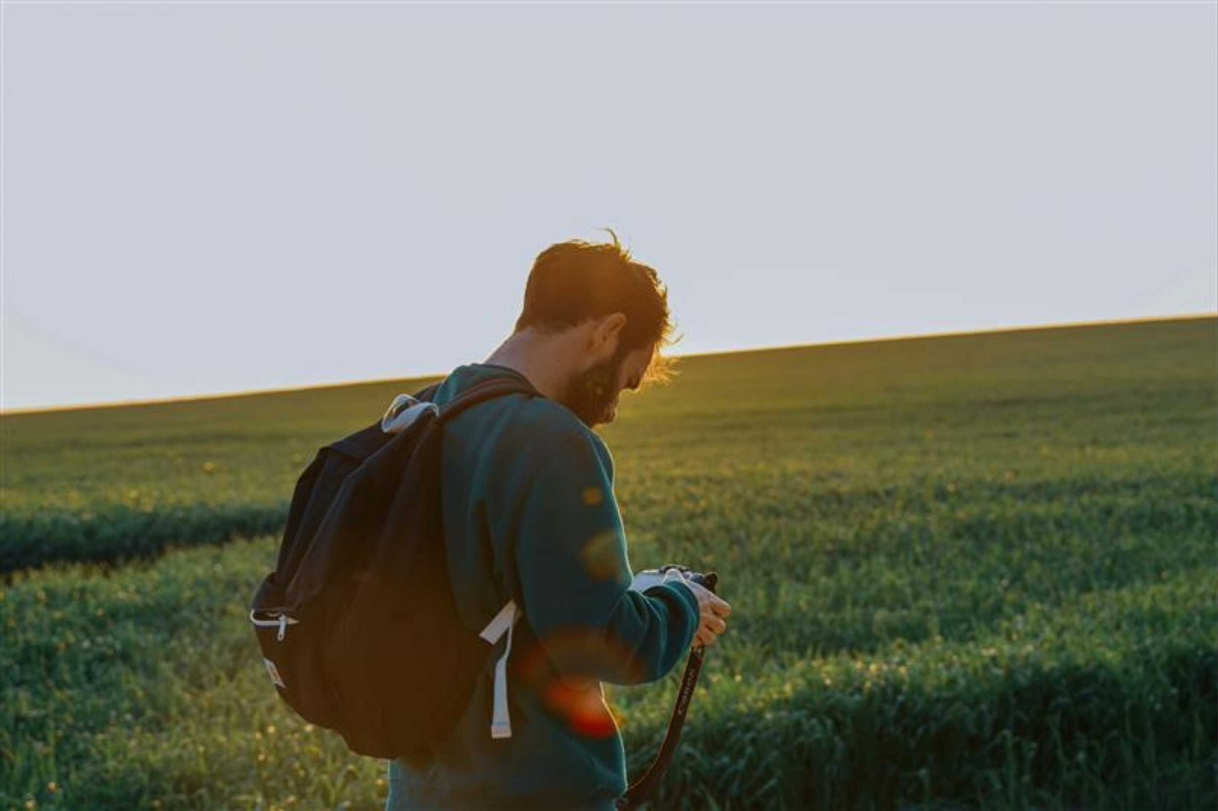Man checking back of camera in field