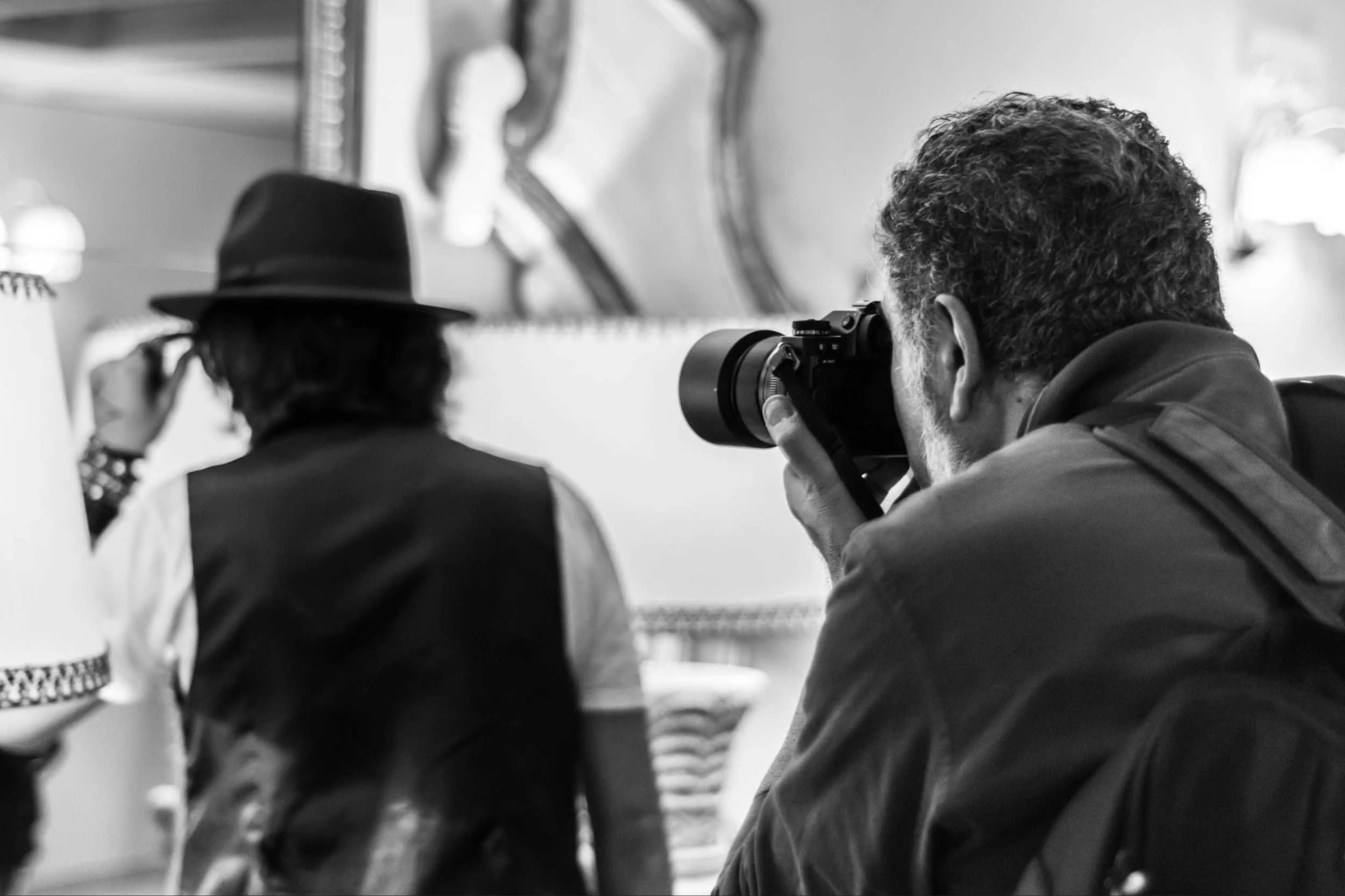 Photographer taking picture of man in hat