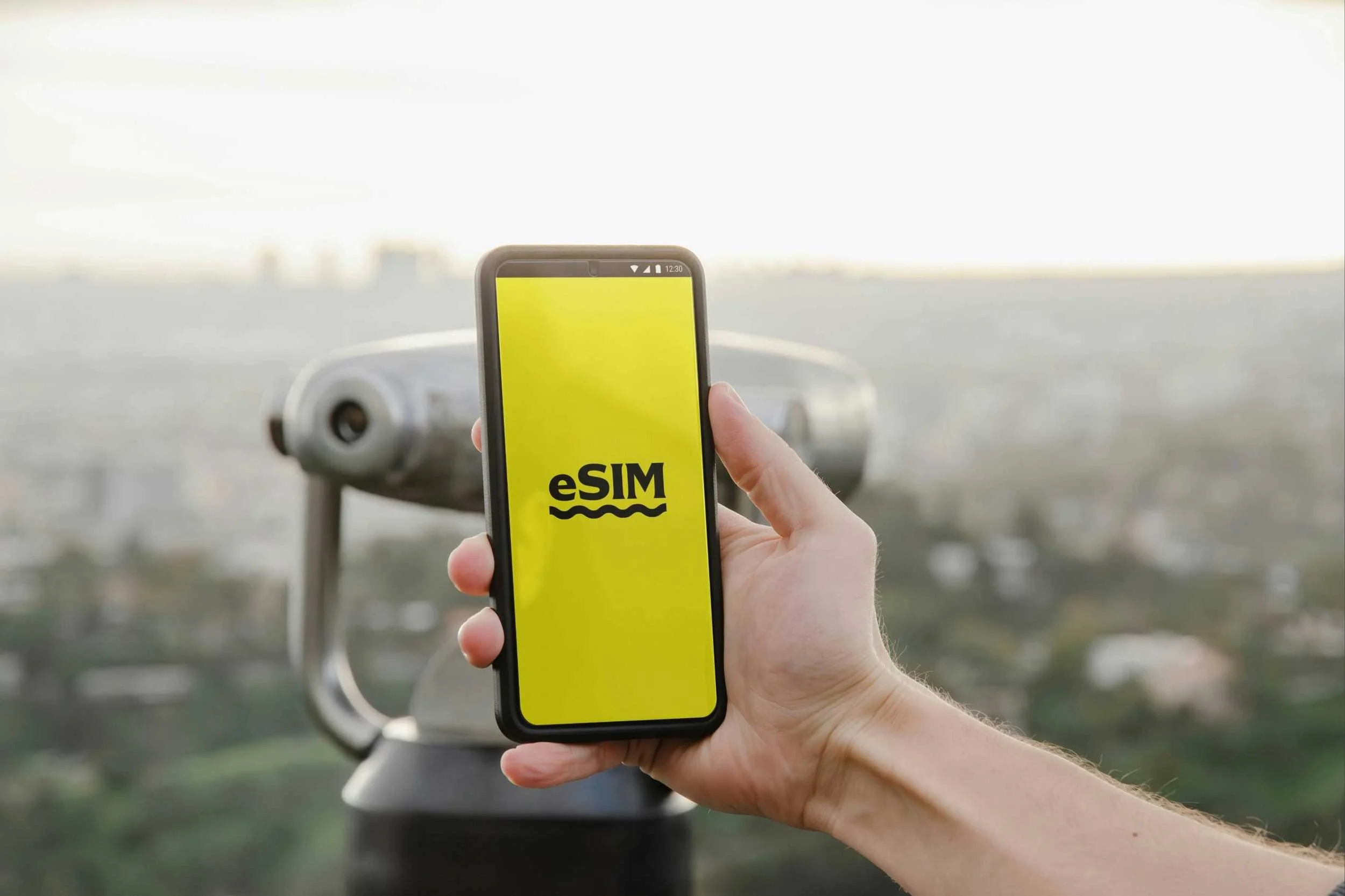 Hand holds mobile near tower viewer