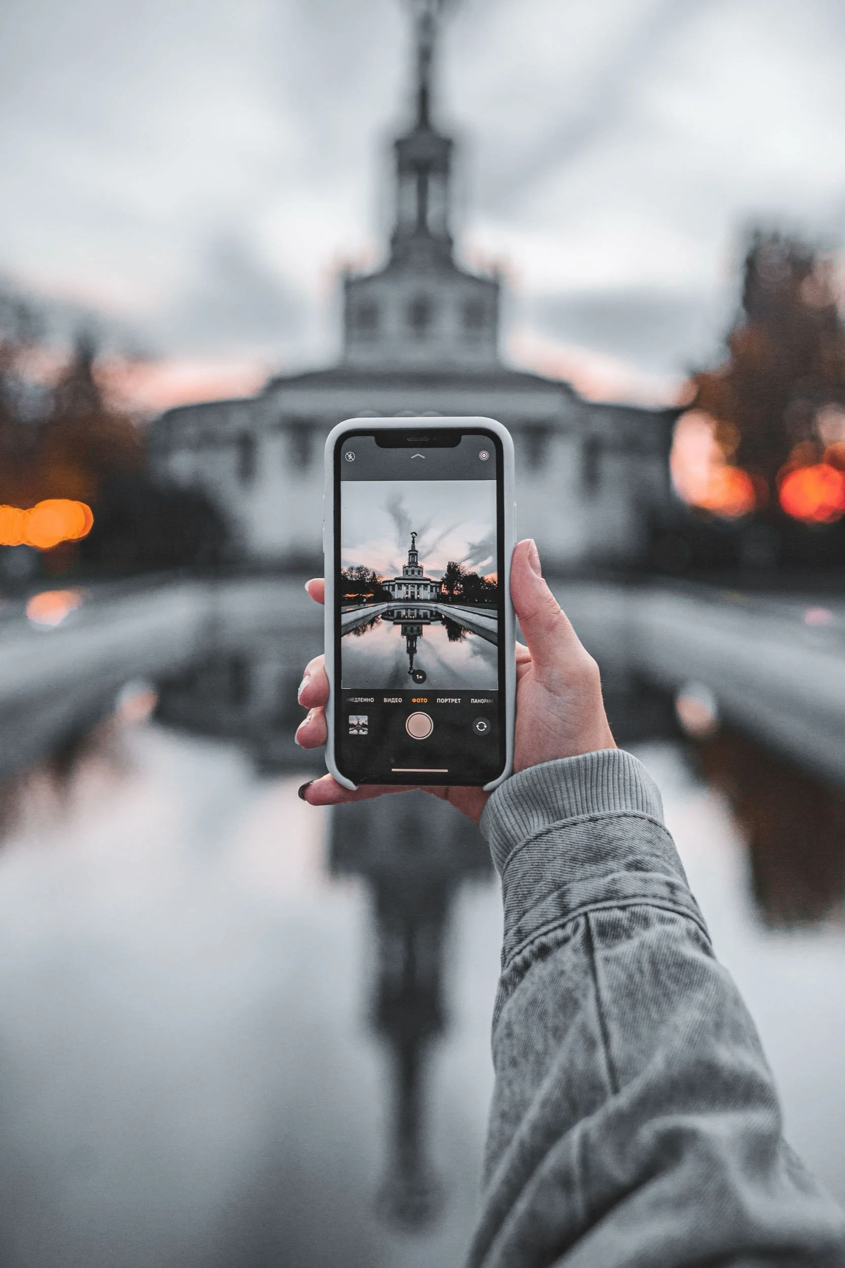 Women photographing old building with smartphone