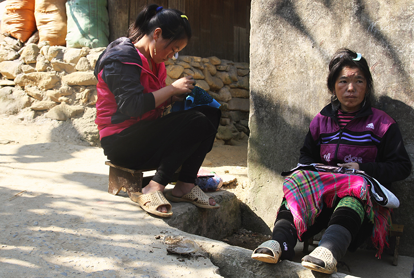 Women embroider outsider their home, Sa Pa