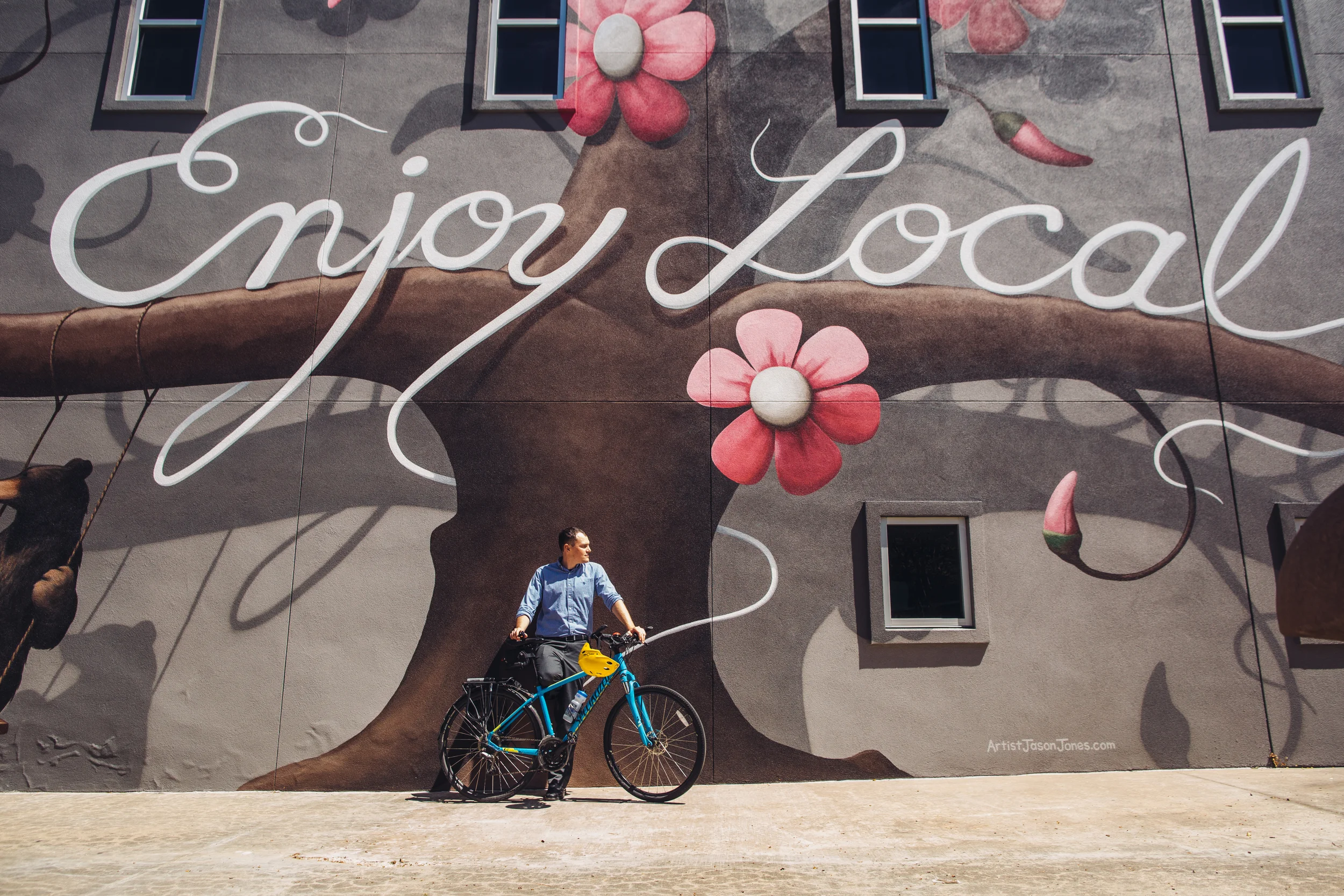Dane Eifling reflects next to the newest mural at the Fayetteville Town Center.