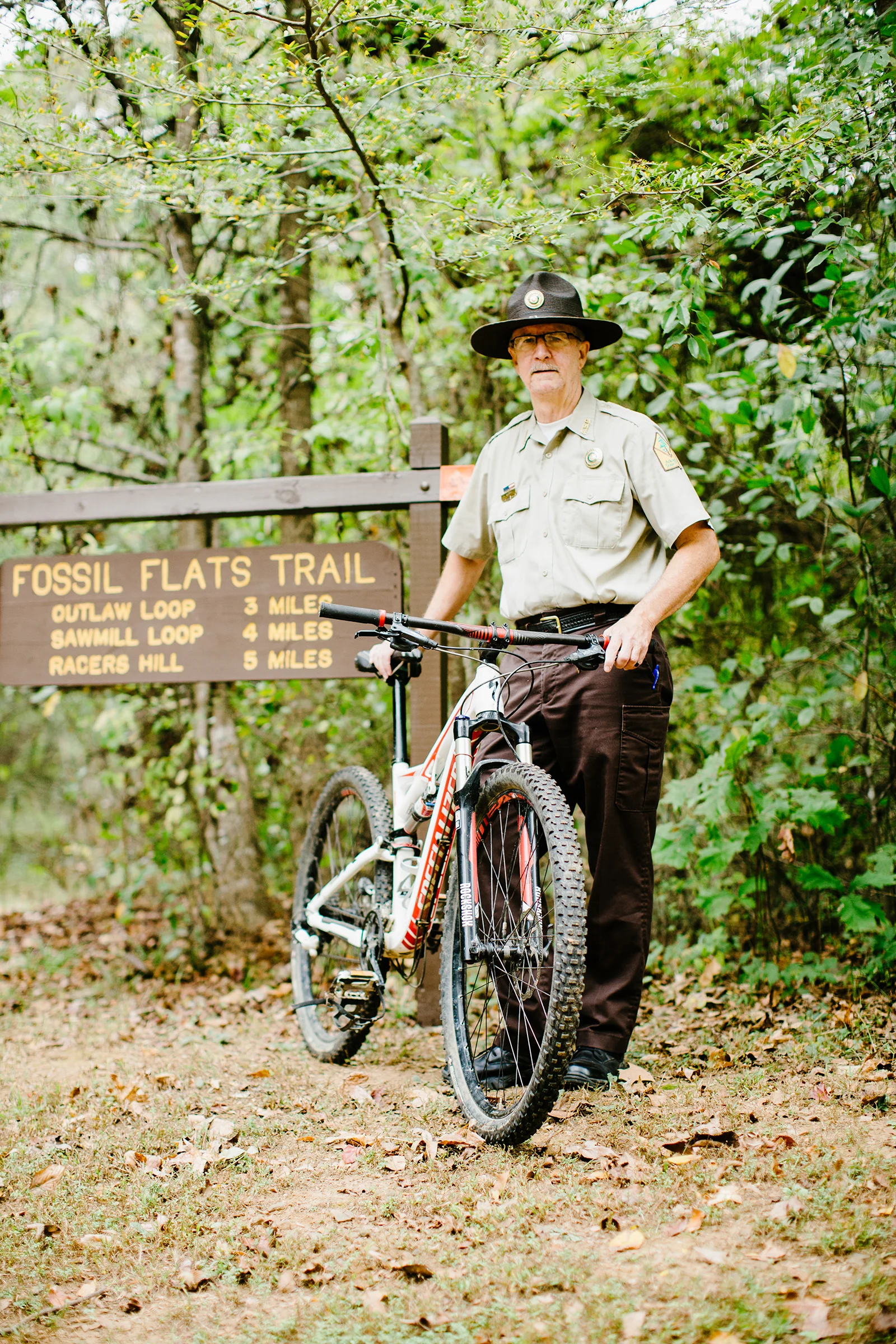 Devil’s Den assistant superintendent Tim Scott stands at the trailhead of the Fossil Flats Trail, one of the first mountain biking trails in the state.