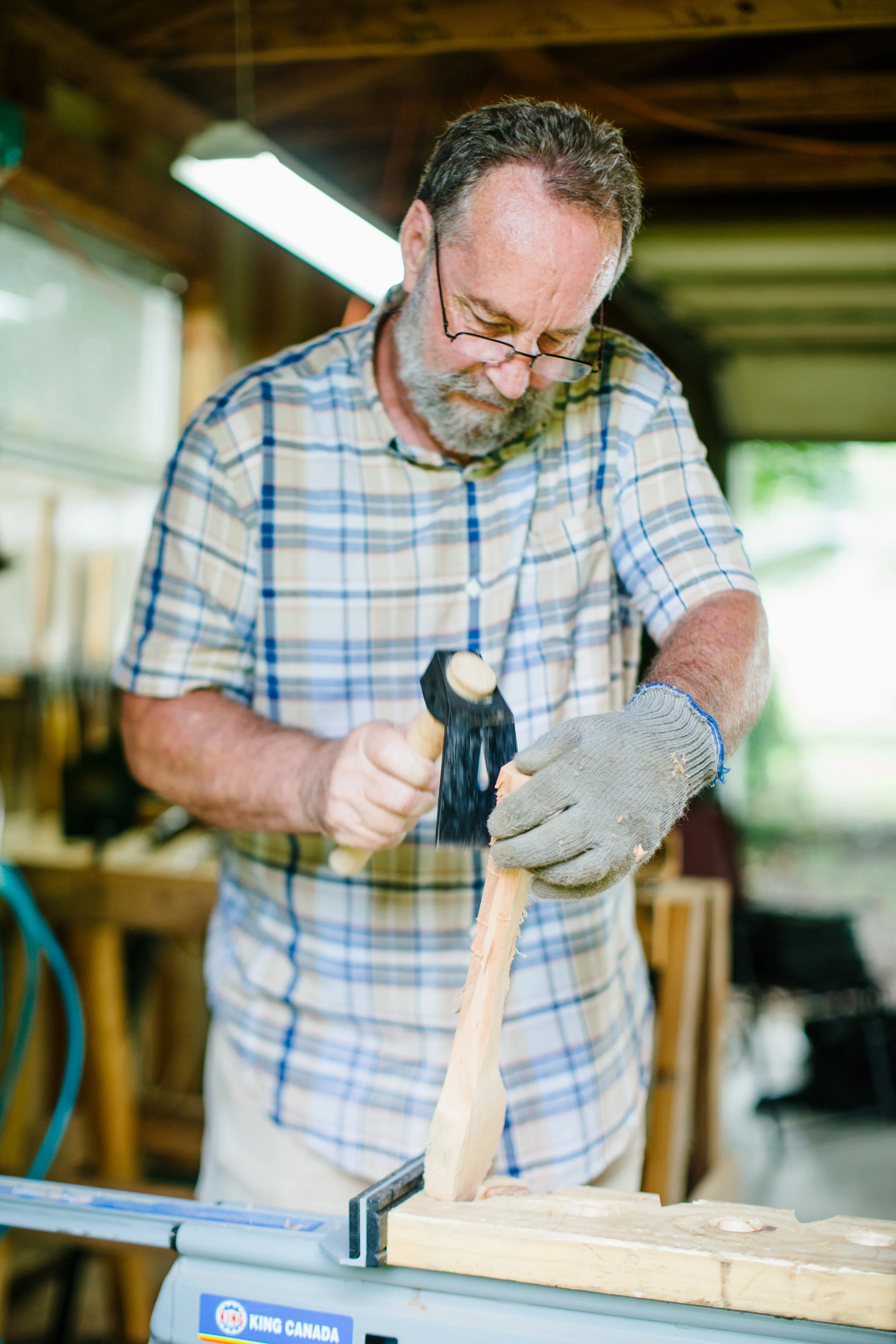 John Kirkpatrick uses an adze to begin roughing out the shape of the spoon.