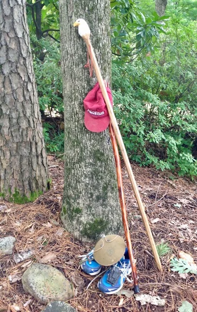 Three essentials Phelps uses on his hiking adventures: baseball cap, tennis shoes, and a hiking stick Phelps was gifted to commemorate his service to Keep Arkansas Beautiful.