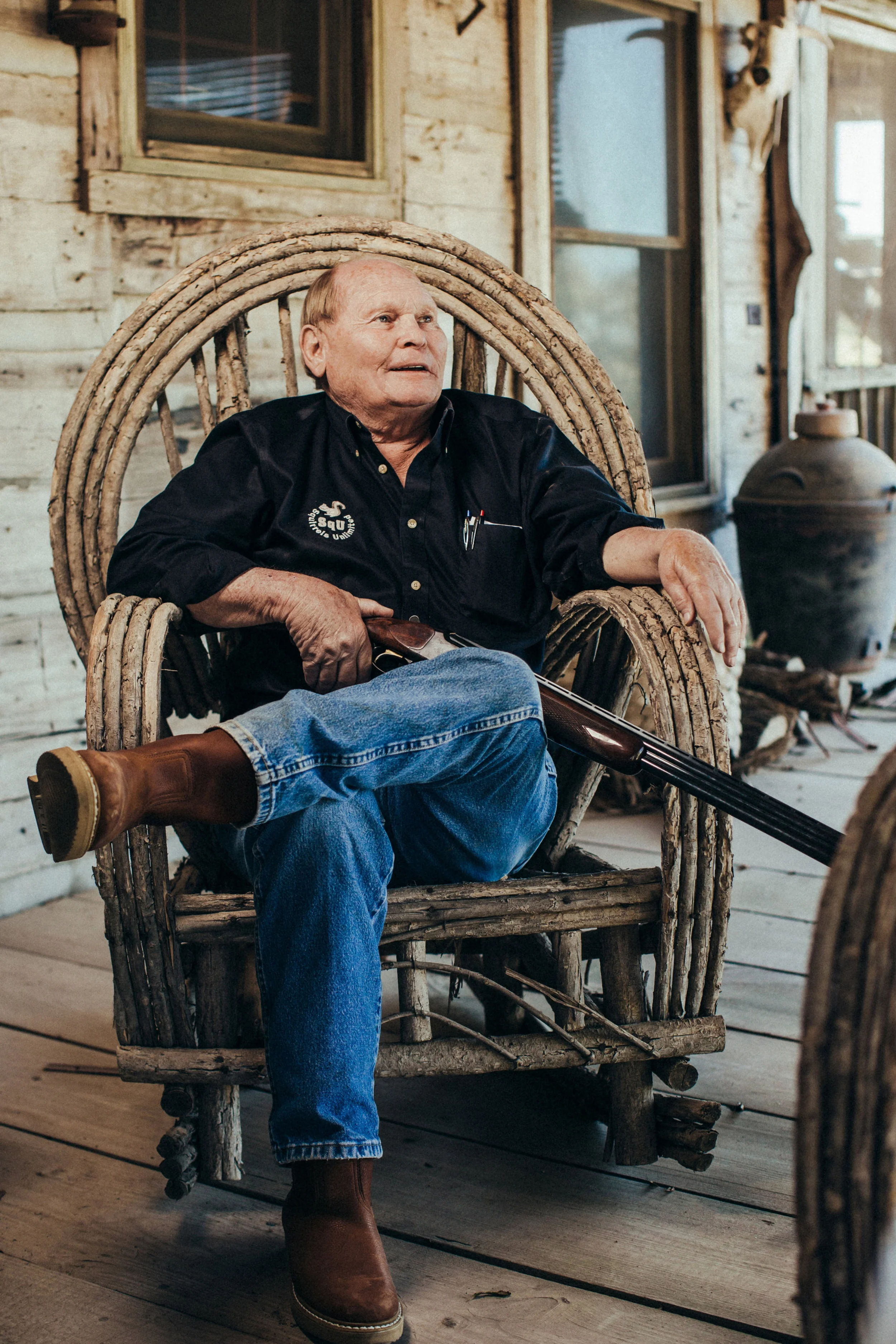 Zach McClendon relaxes on the porch of his cabin at his hunting camp in Tillar.